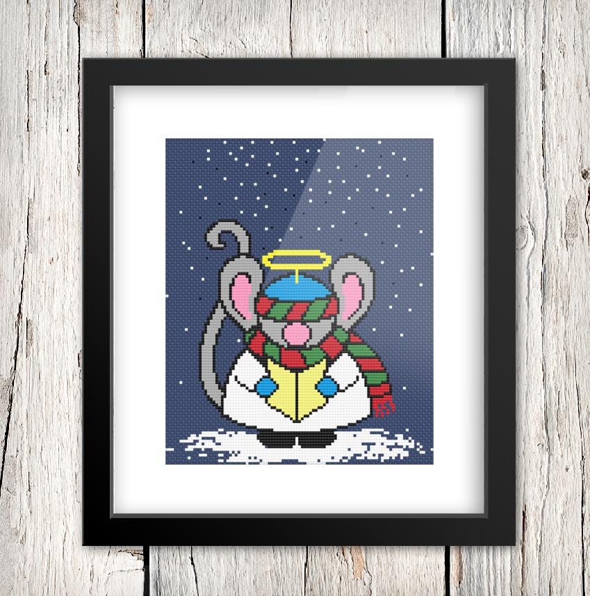 A framed cross-stitch image depicting a cartoon mouse wearing a hat and scarf, set against a snowy background with a starry night sky.