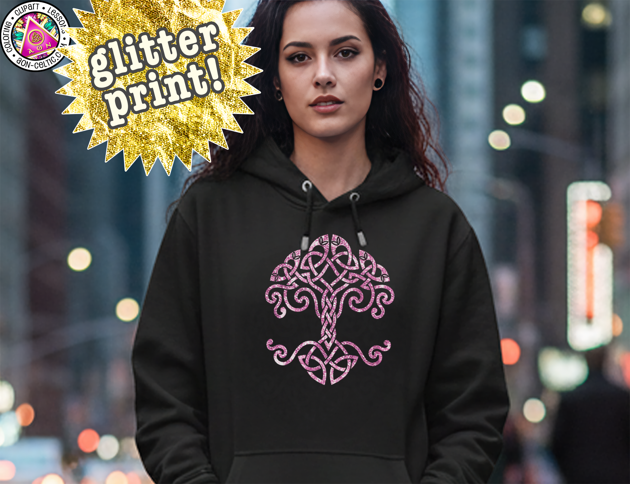 A woman wearing a black hoodie with a pink tree design stands in a city street at night, with a glitter print banner above her.