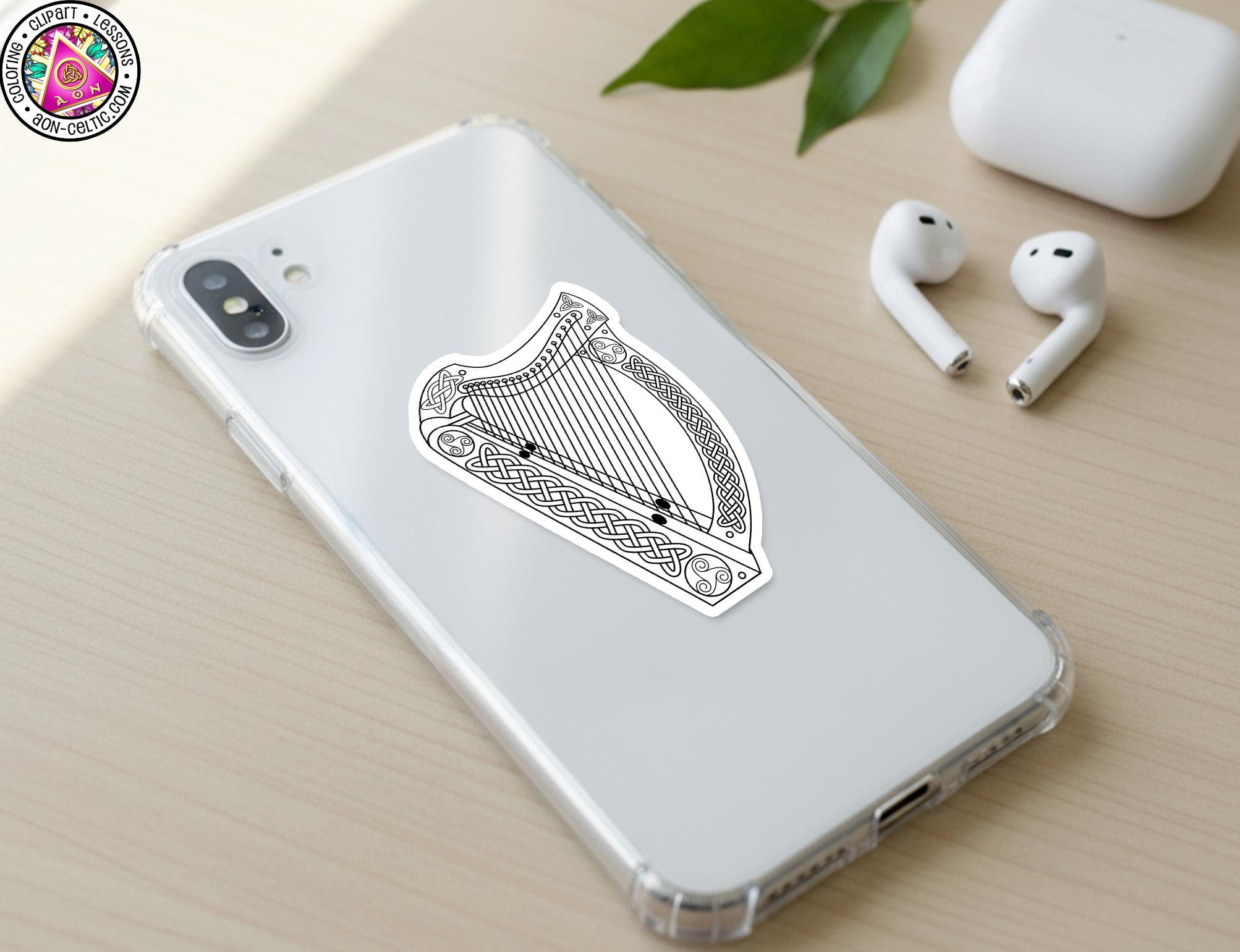 a smartphone with a sticker of a harp on its back cover, along with a pair of earbuds and a white earbud case.