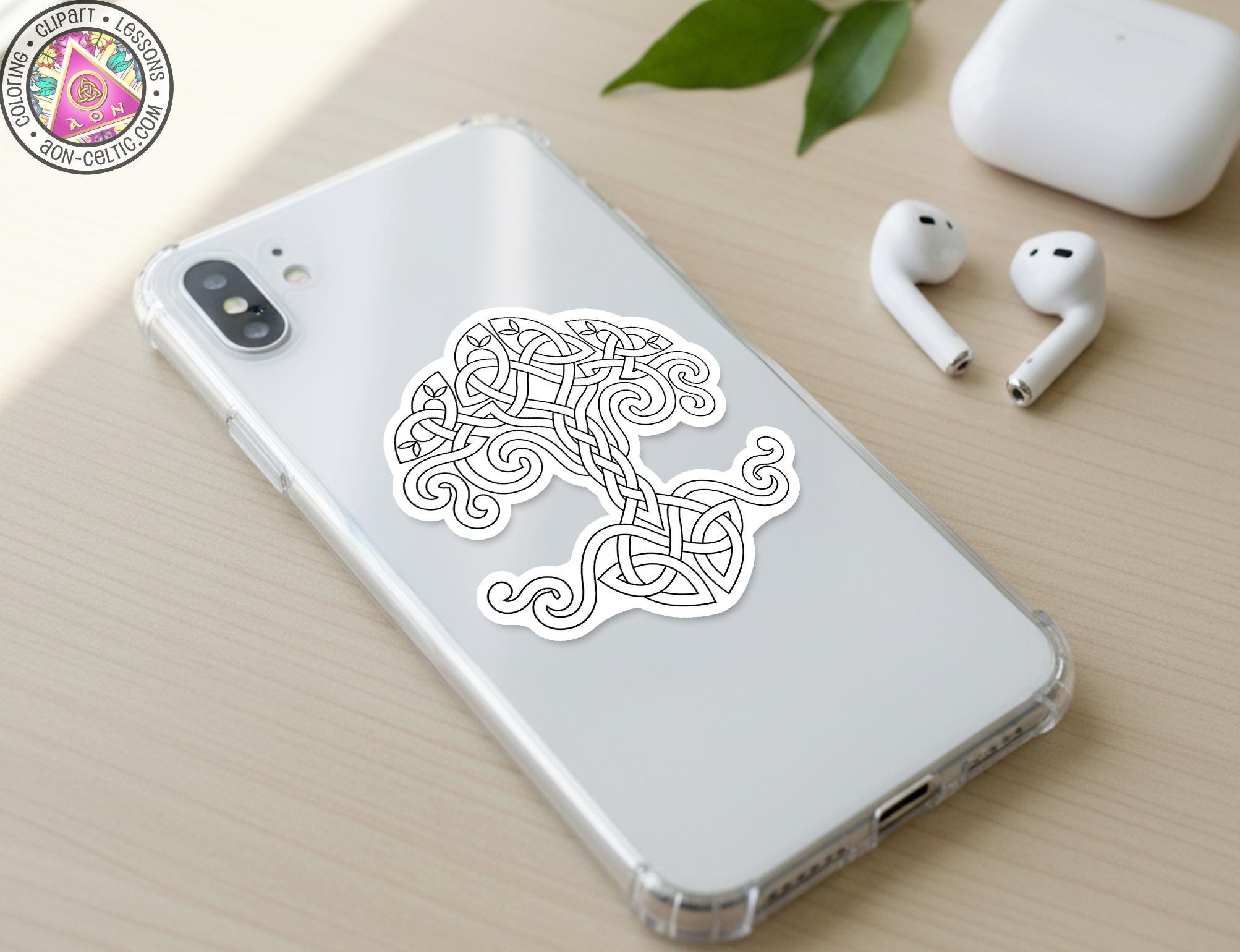 a smartphone with a sticker of a tree design on its back cover, along with a pair of earbuds and a white earbud case on a wooden surface.