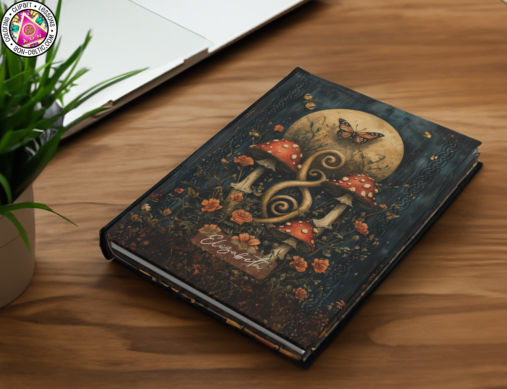 a book sitting on top of a wooden table next to a laptop