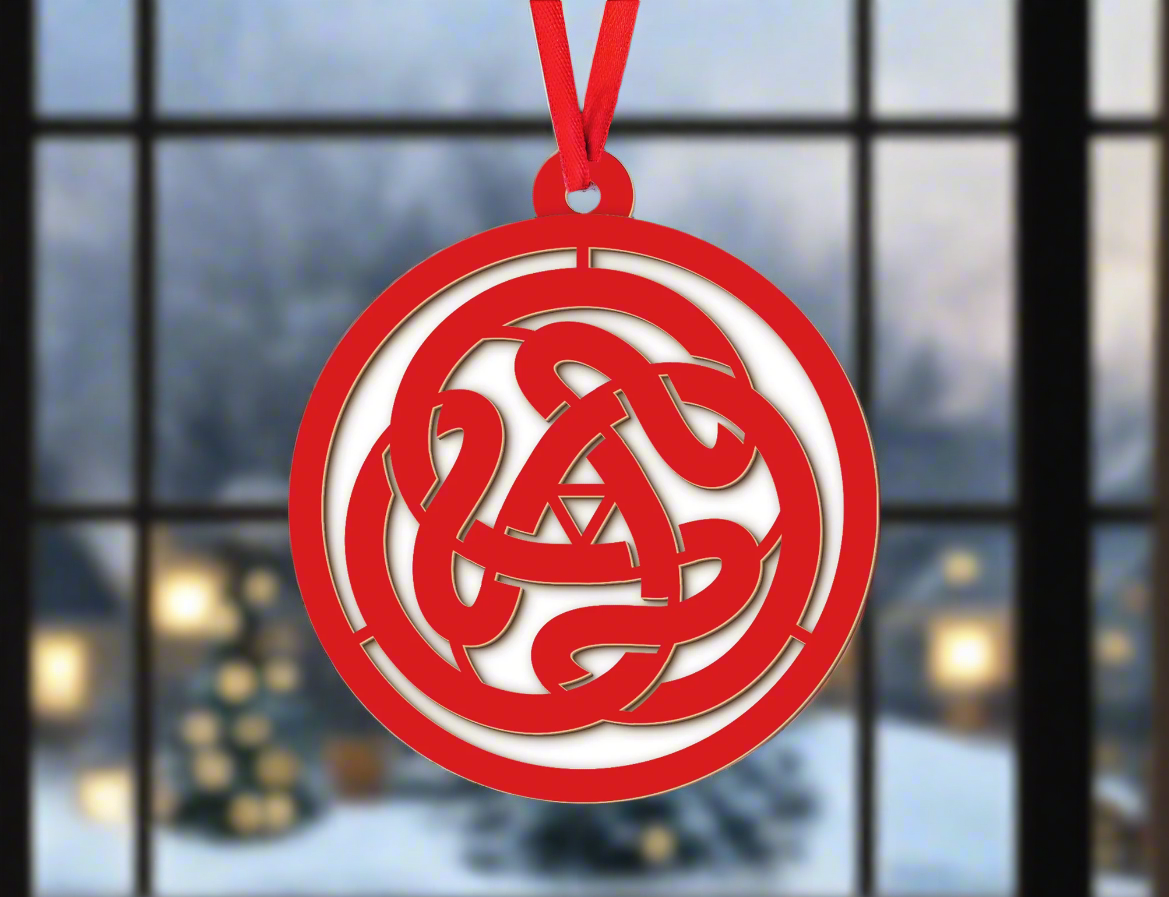 a red ornament hanging from a christmas tree