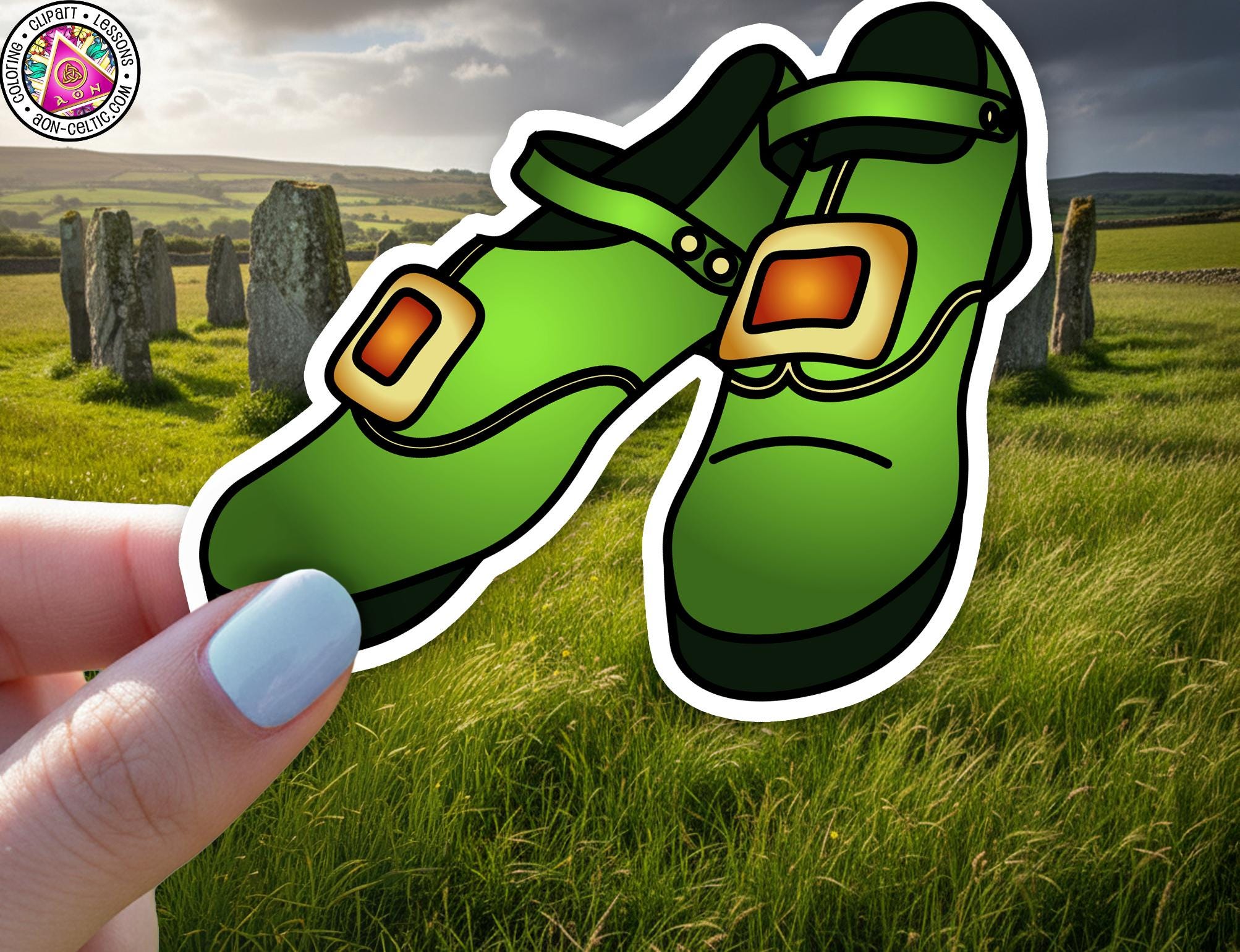 A hand holding a green shoe with a red square on the toe, set against a pastoral landscape with a field and stone markers in the background.