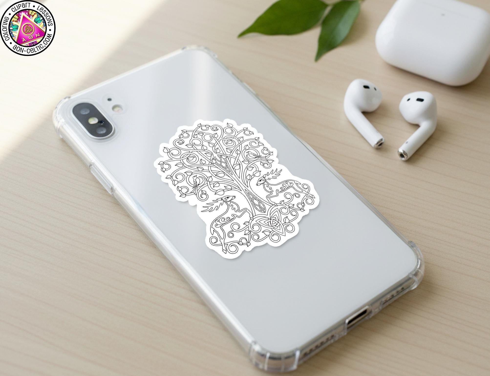 a smartphone with a sticker of a tree on its back cover, along with a pair of white earbuds and a white charging cable on a wooden surface.