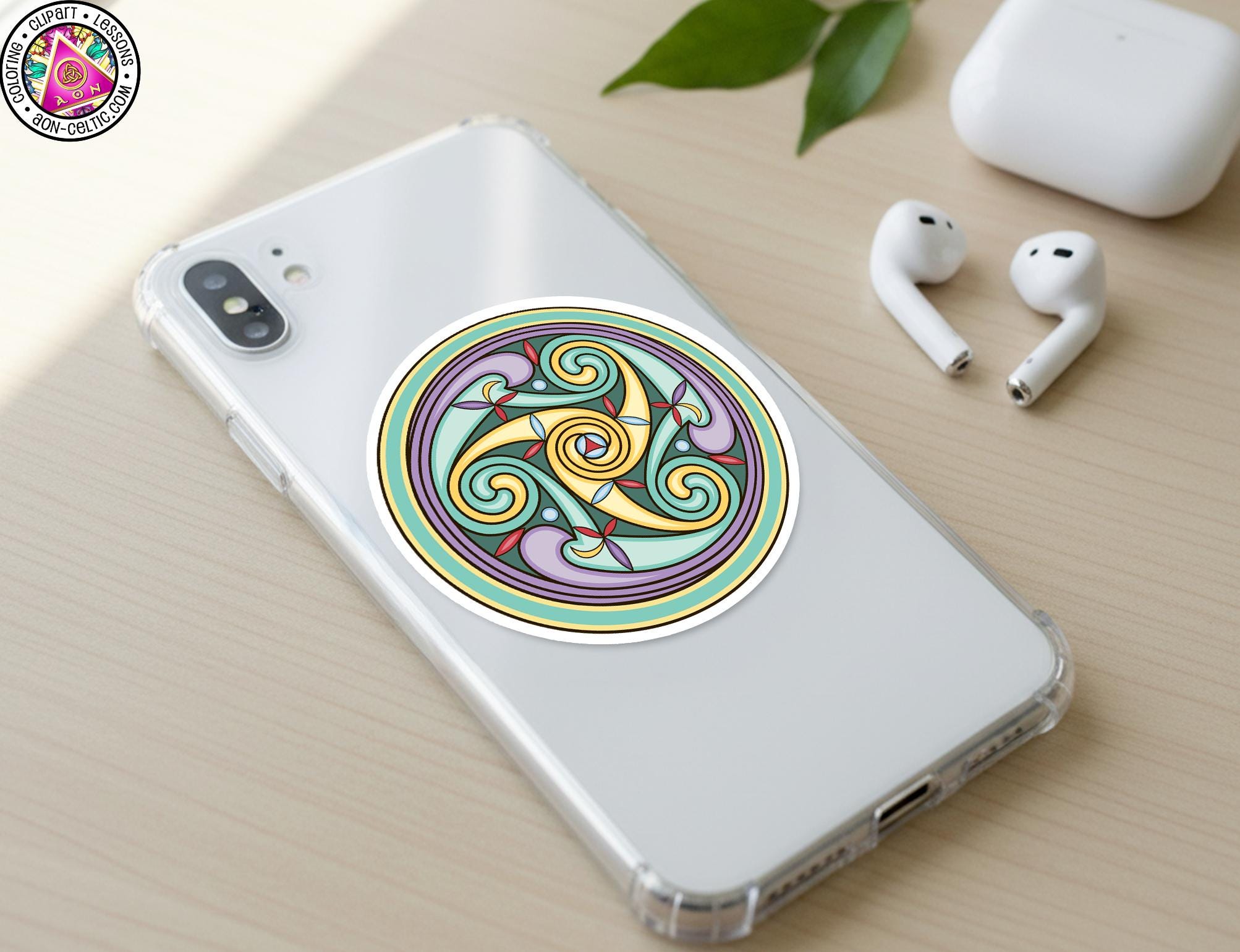 a smartphone with a colorful, circular sticker on its back cover, along with a pair of white earbuds and a white earbud case on a wooden surface.