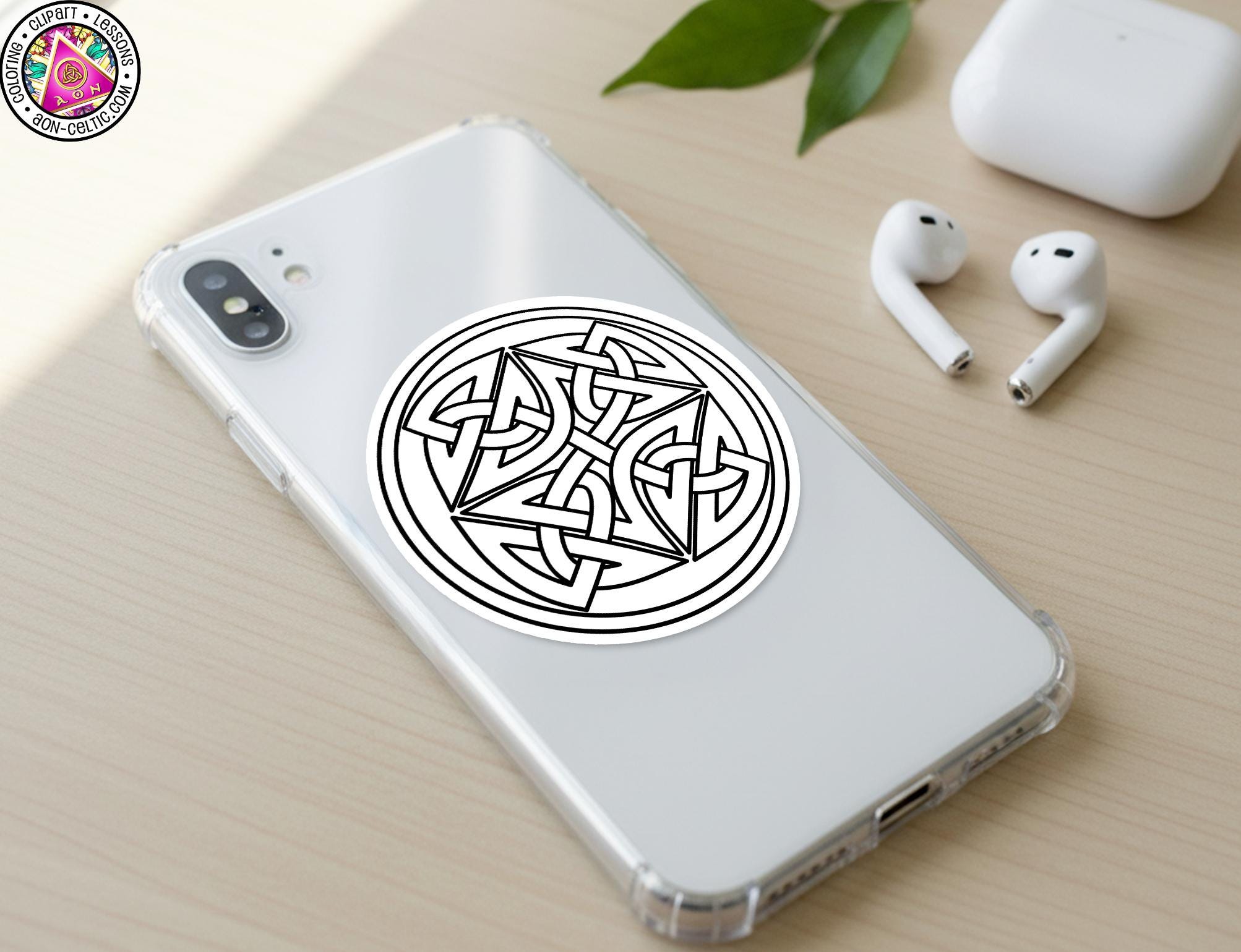 a smartphone with a sticker of a Celtic knot design on its back cover, along with a pair of white earbuds and a white phone case.