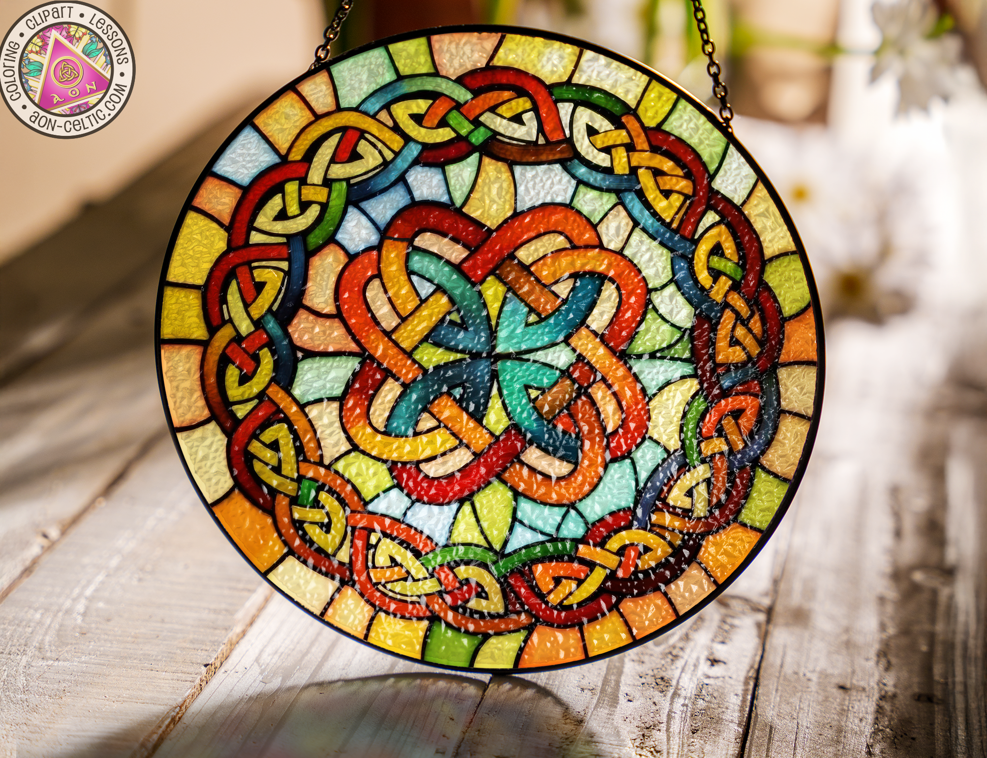 a stained glass hanging decoration on a wooden table