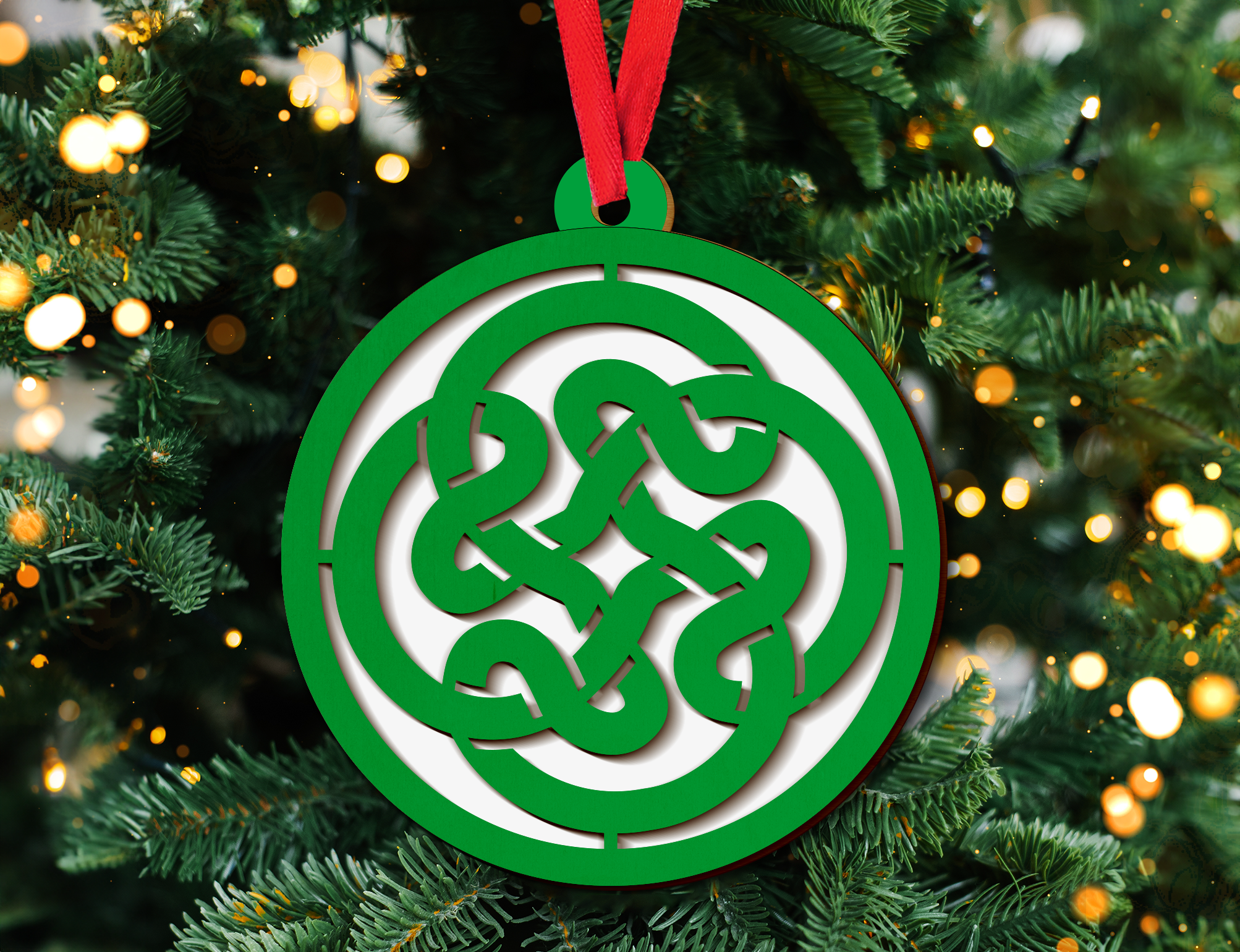 a green and white ornament hanging from a christmas tree