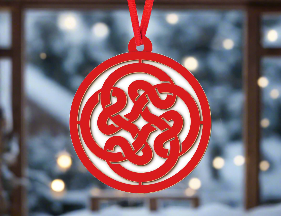 a red ornament hanging from a christmas tree