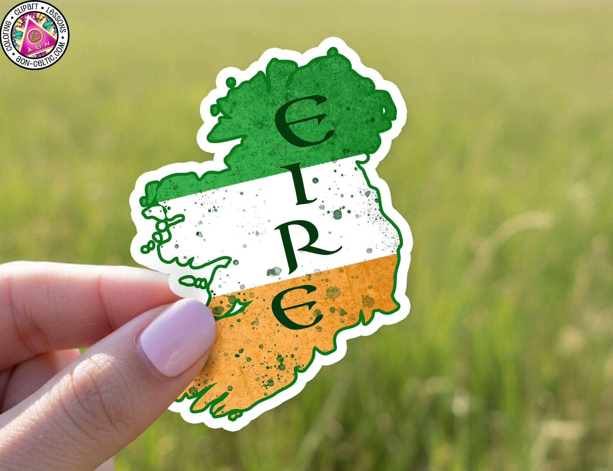 A hand holding a sticker with the word "IRE" on it, which is part of the Irish flag.