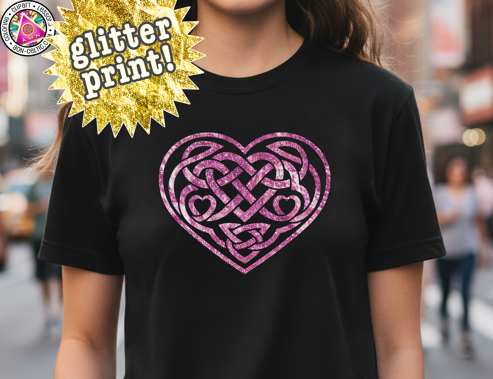 A person wearing a black t-shirt with a pink heart-shaped design featuring a Celtic knot pattern.