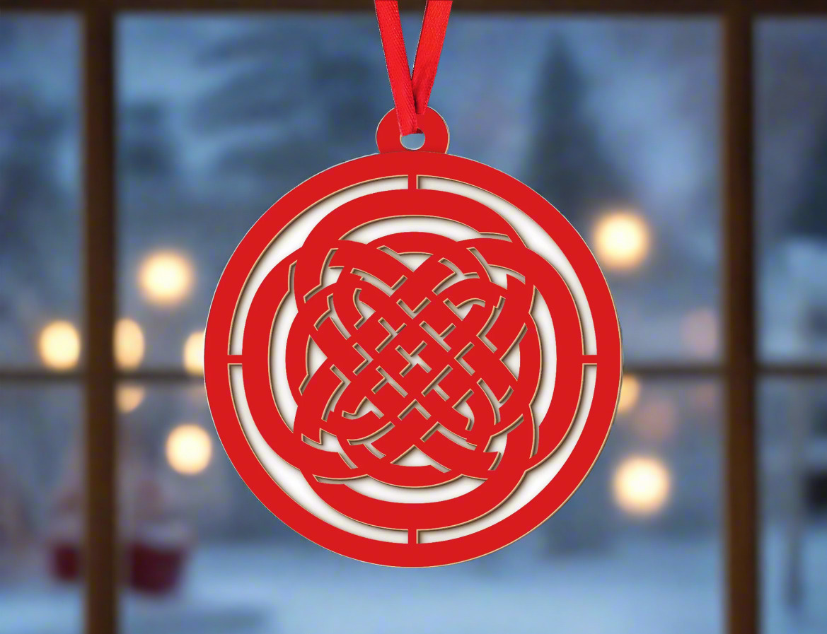 a red ornament hanging from a christmas tree