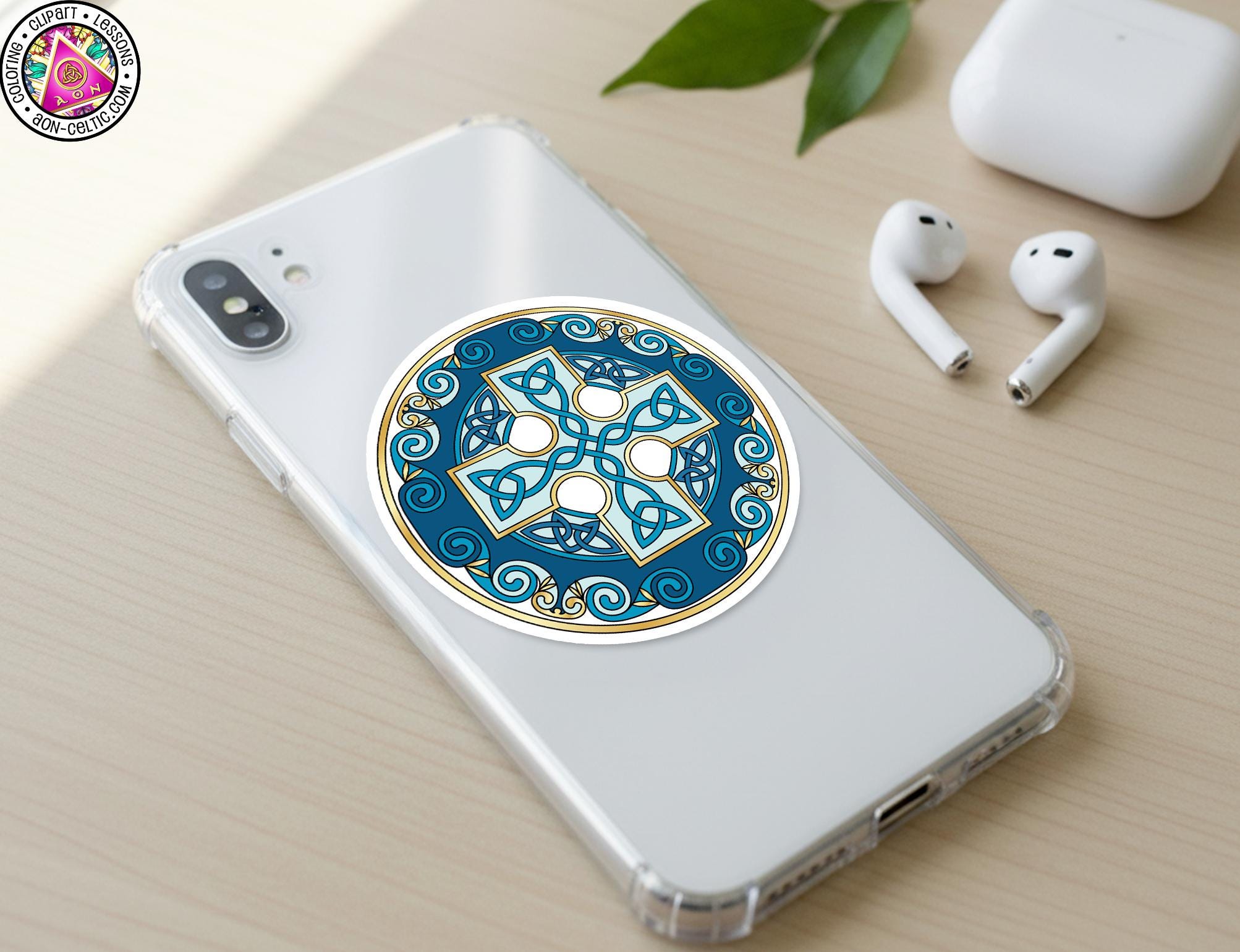 a smartphone with a decorative sticker on the back cover, along with a pair of earbuds and a white earbud case on a wooden surface.