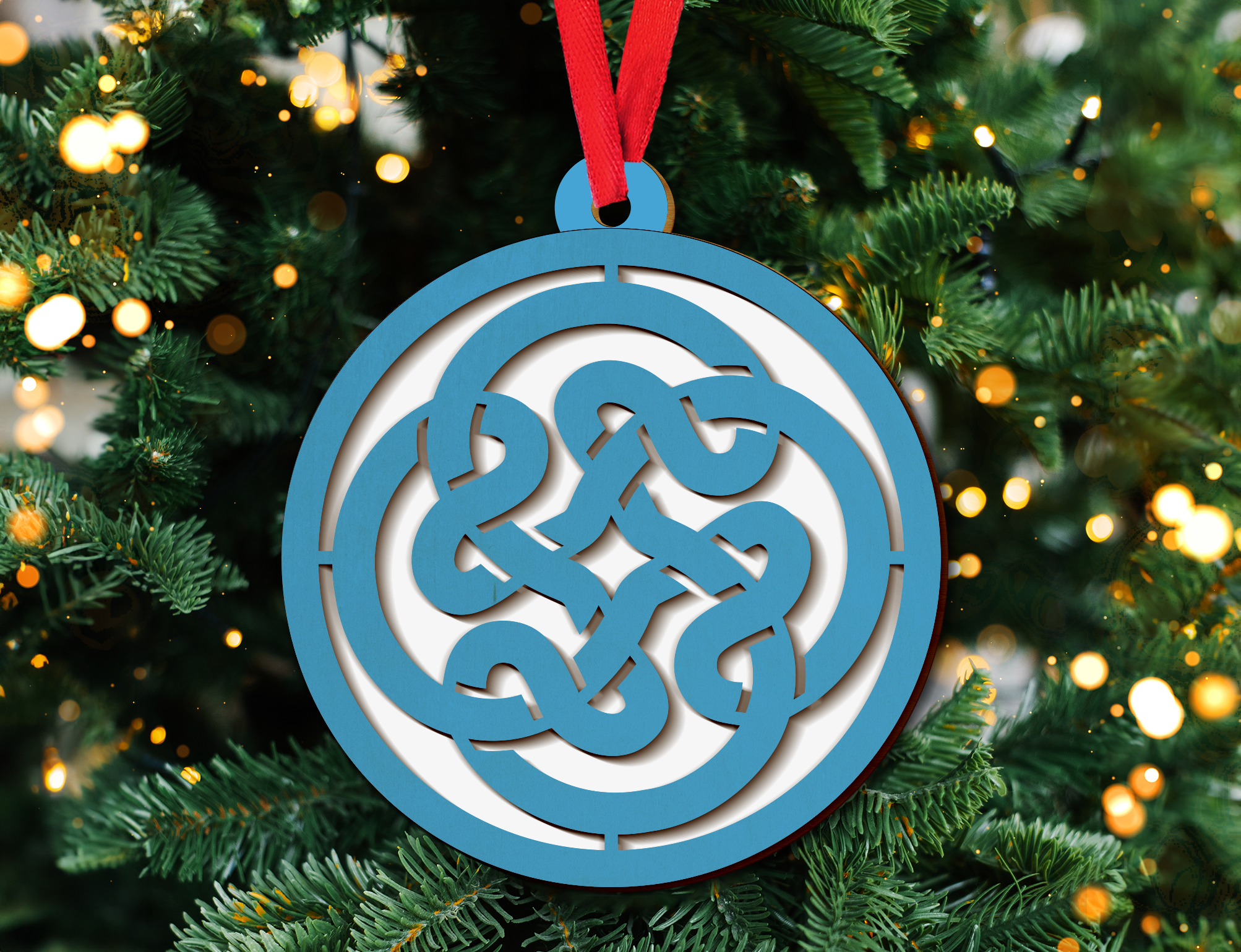 a blue and white ornament hanging from a christmas tree