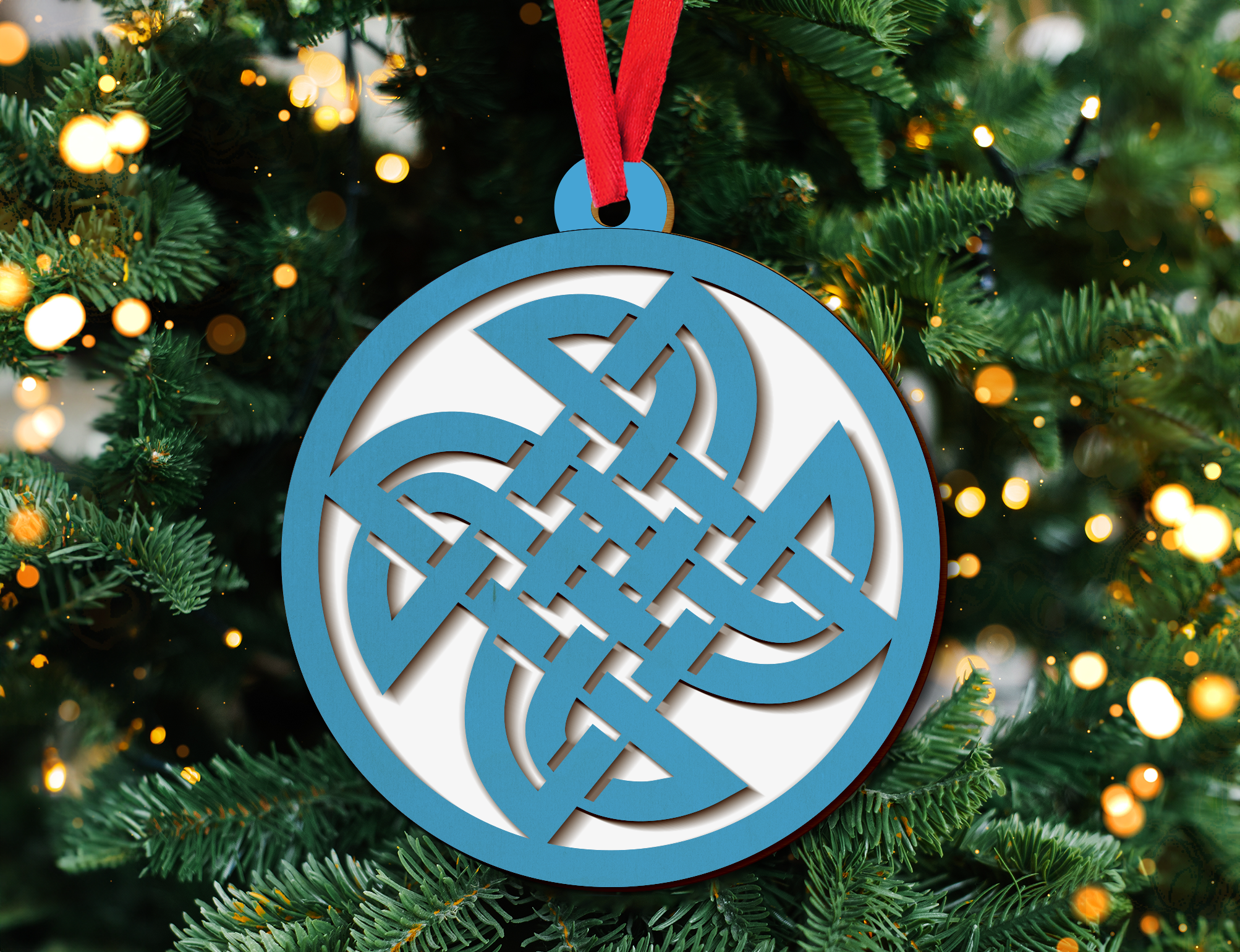 a blue and white ornament hanging from a christmas tree