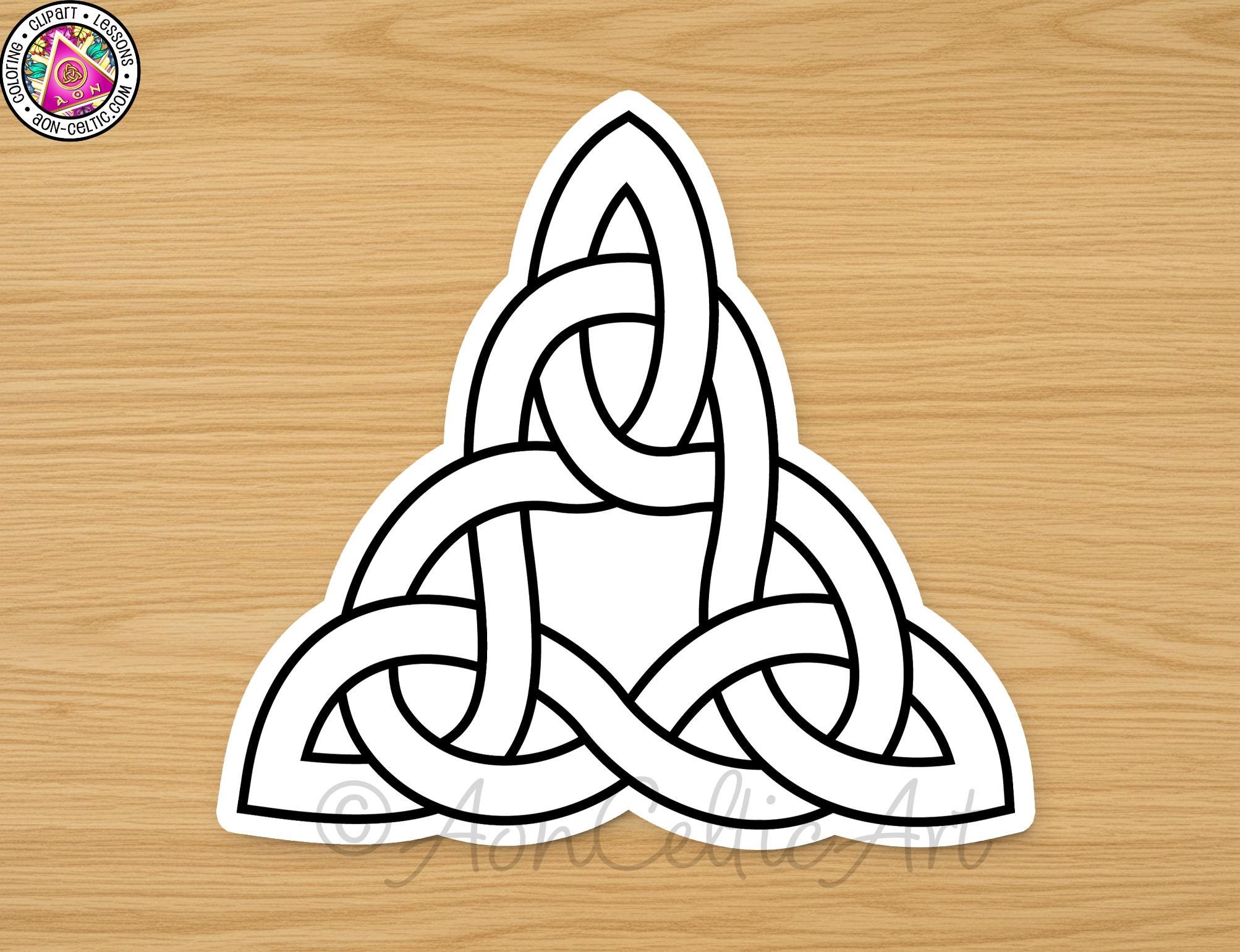 A white sticker depicting a Celtic knot design on a wooden surface.