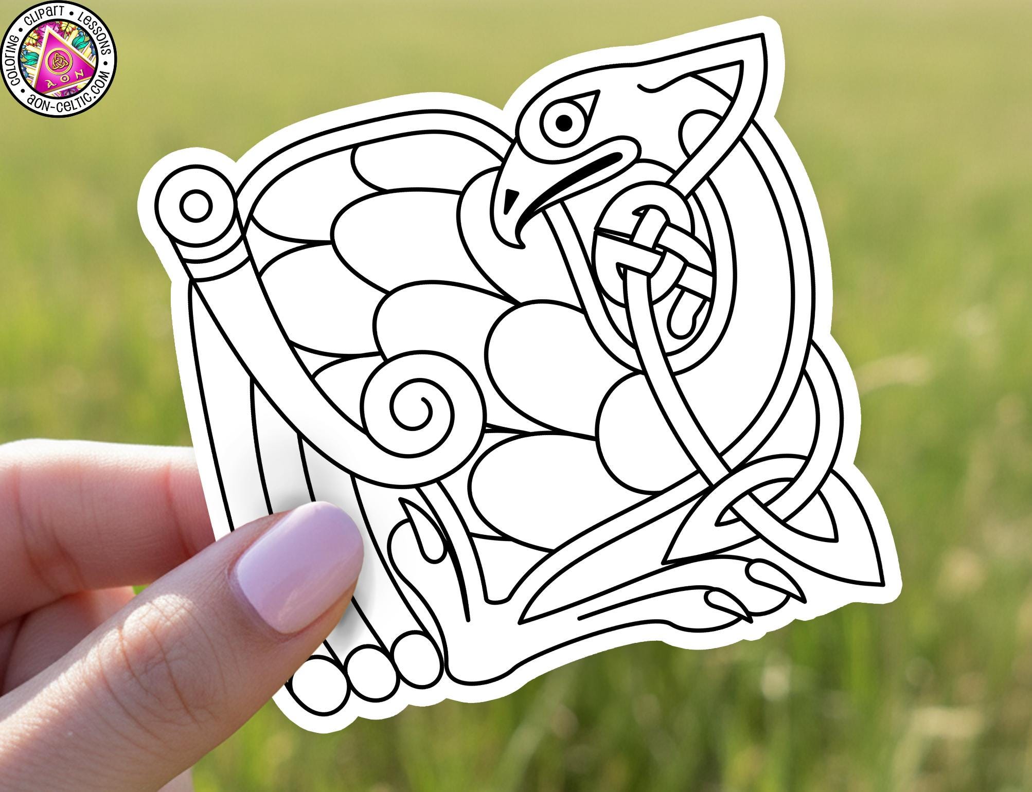 A hand holding a sticker with a stylized bird design on it.