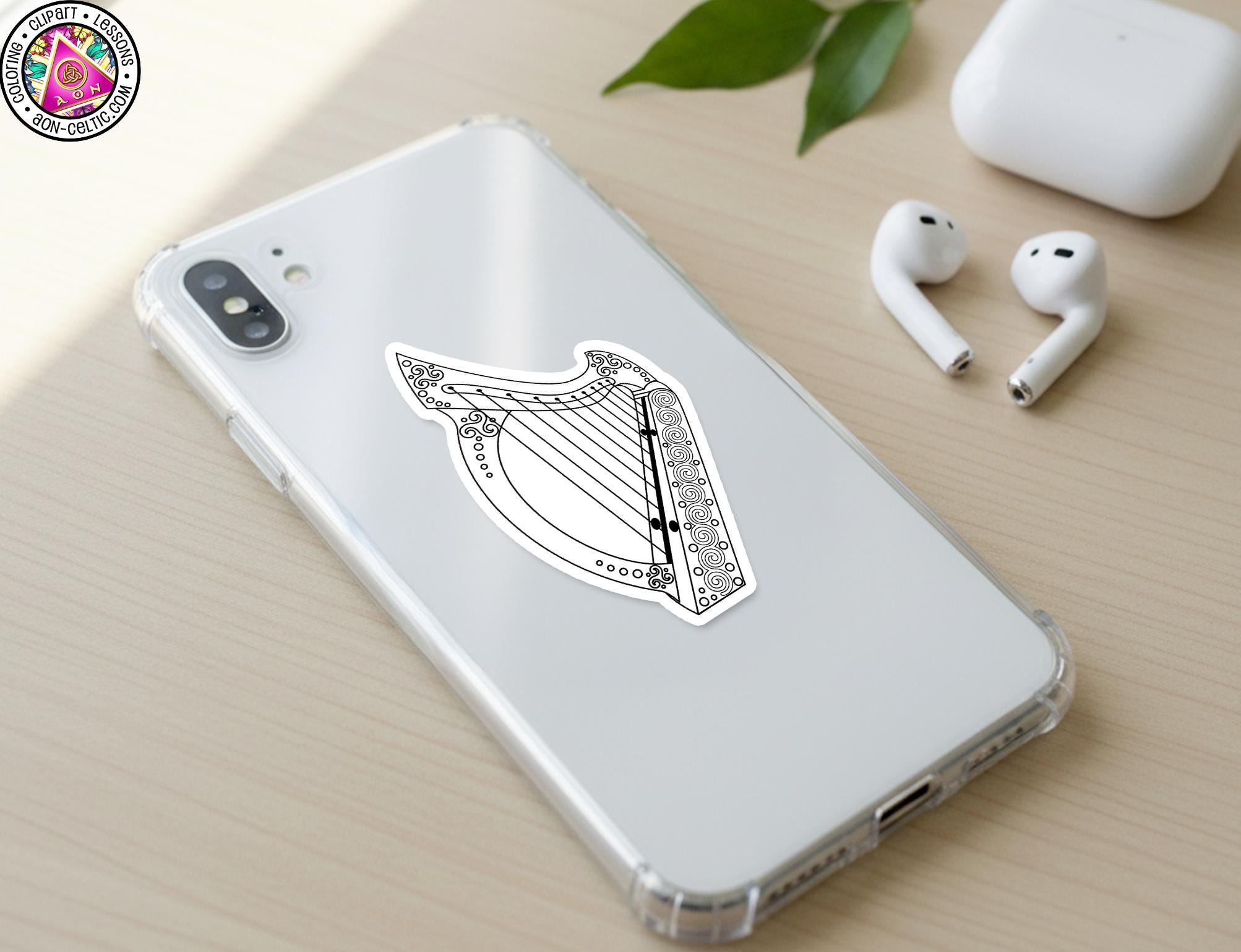 a smartphone with a sticker of a harp on its back cover, along with a pair of earbuds and a white earbud case.