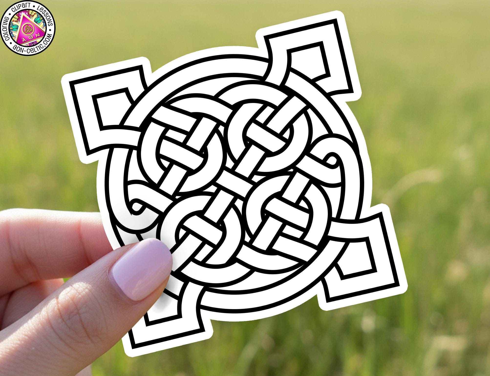 A hand holding a sticker with a geometric design featuring interlocking shapes and lines.