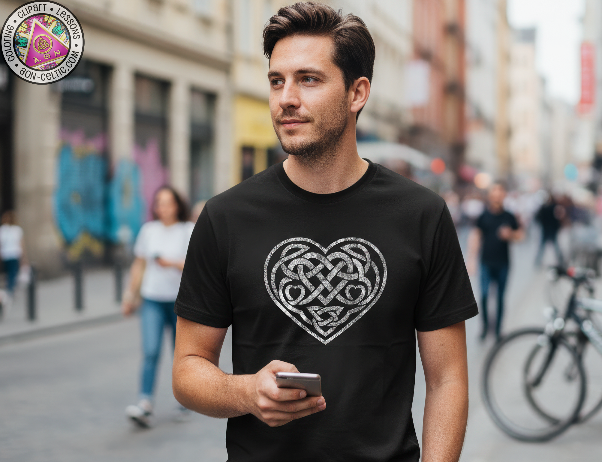 A man wearing a black t-shirt with a heart design is walking down a city street while holding a smartphone.