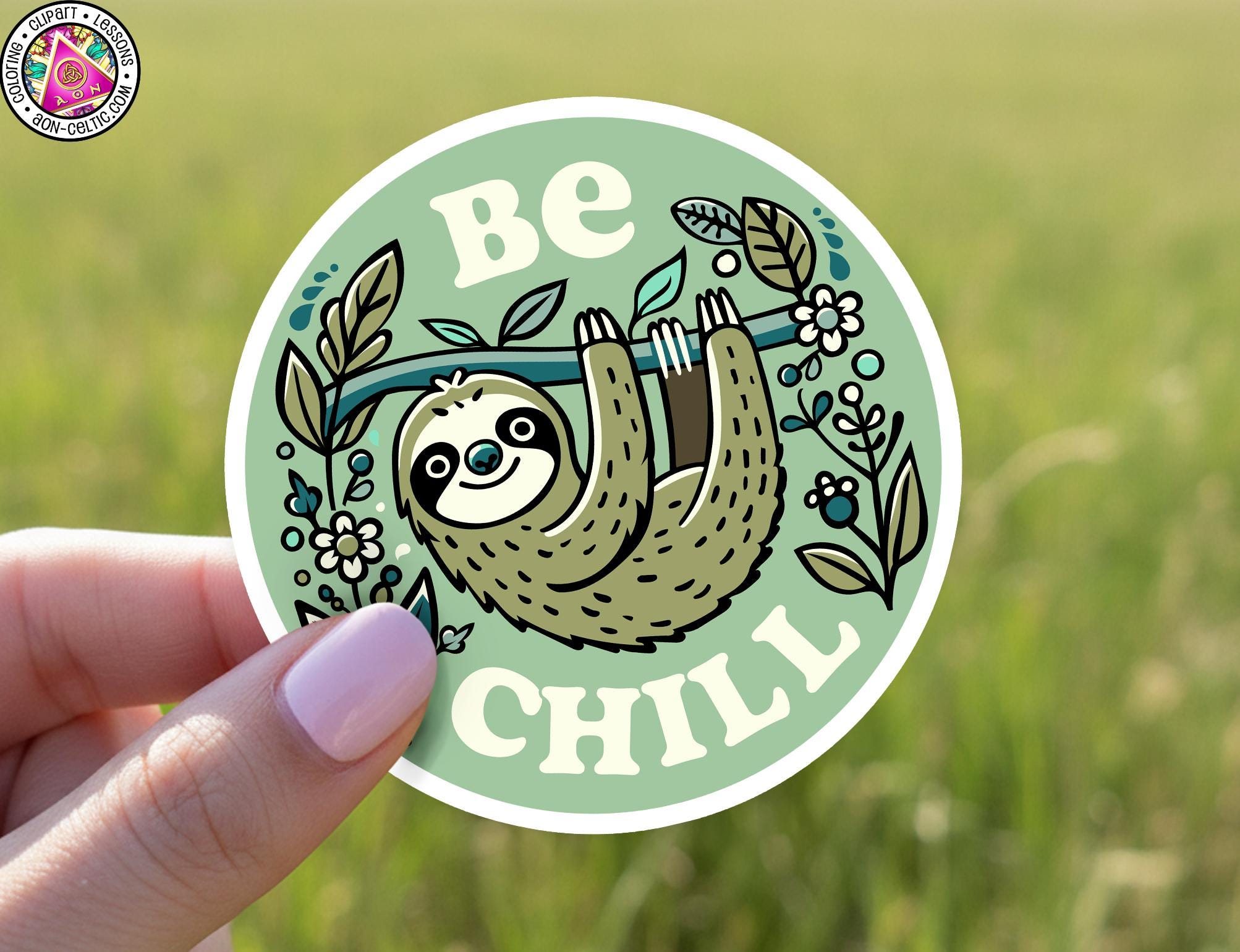 A hand holding a sticker with a sloth hanging upside down and the text "Be Chill" written on it.