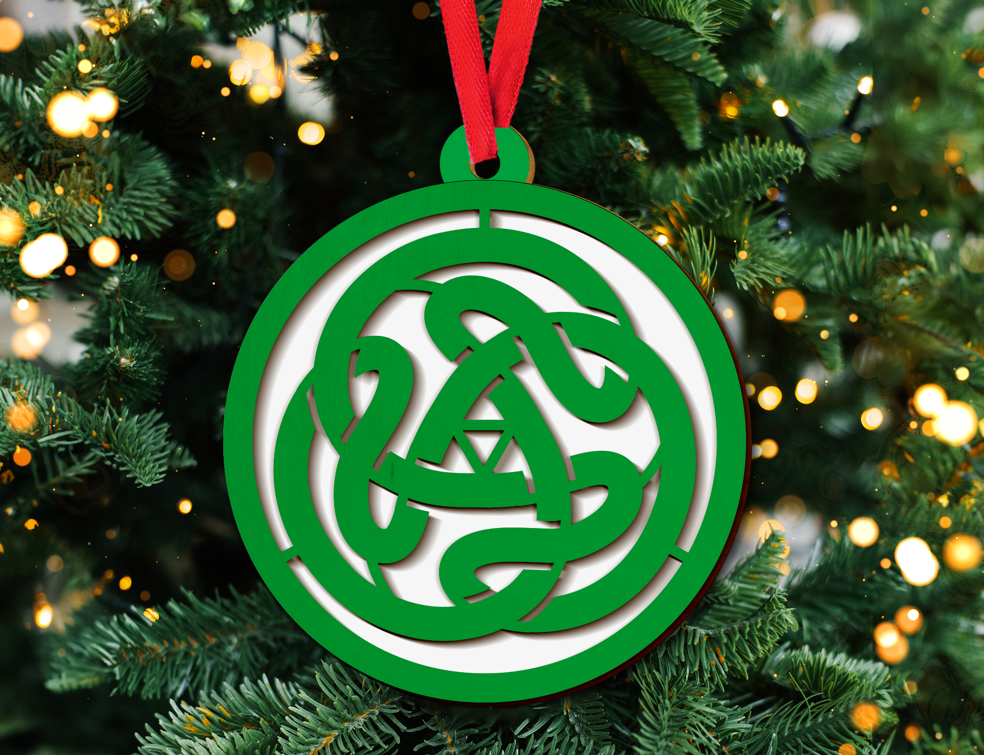 a green and white ornament hanging from a christmas tree