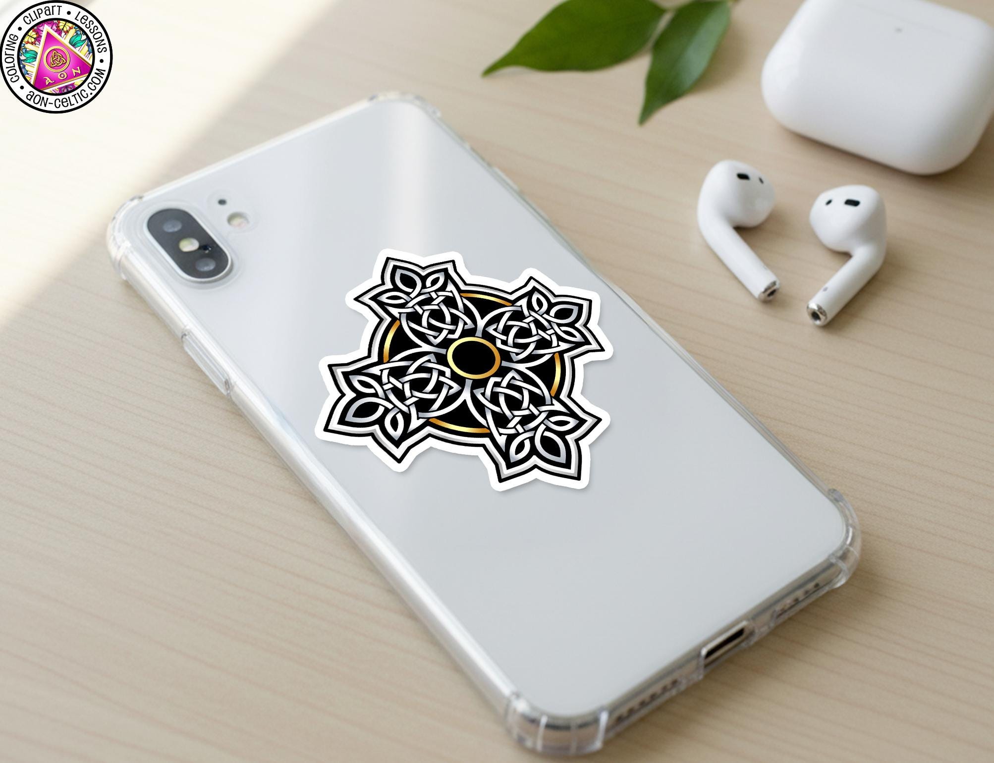 a smartphone with a sticker on the back, along with a pair of earbuds and a white earbud case on a wooden surface.
