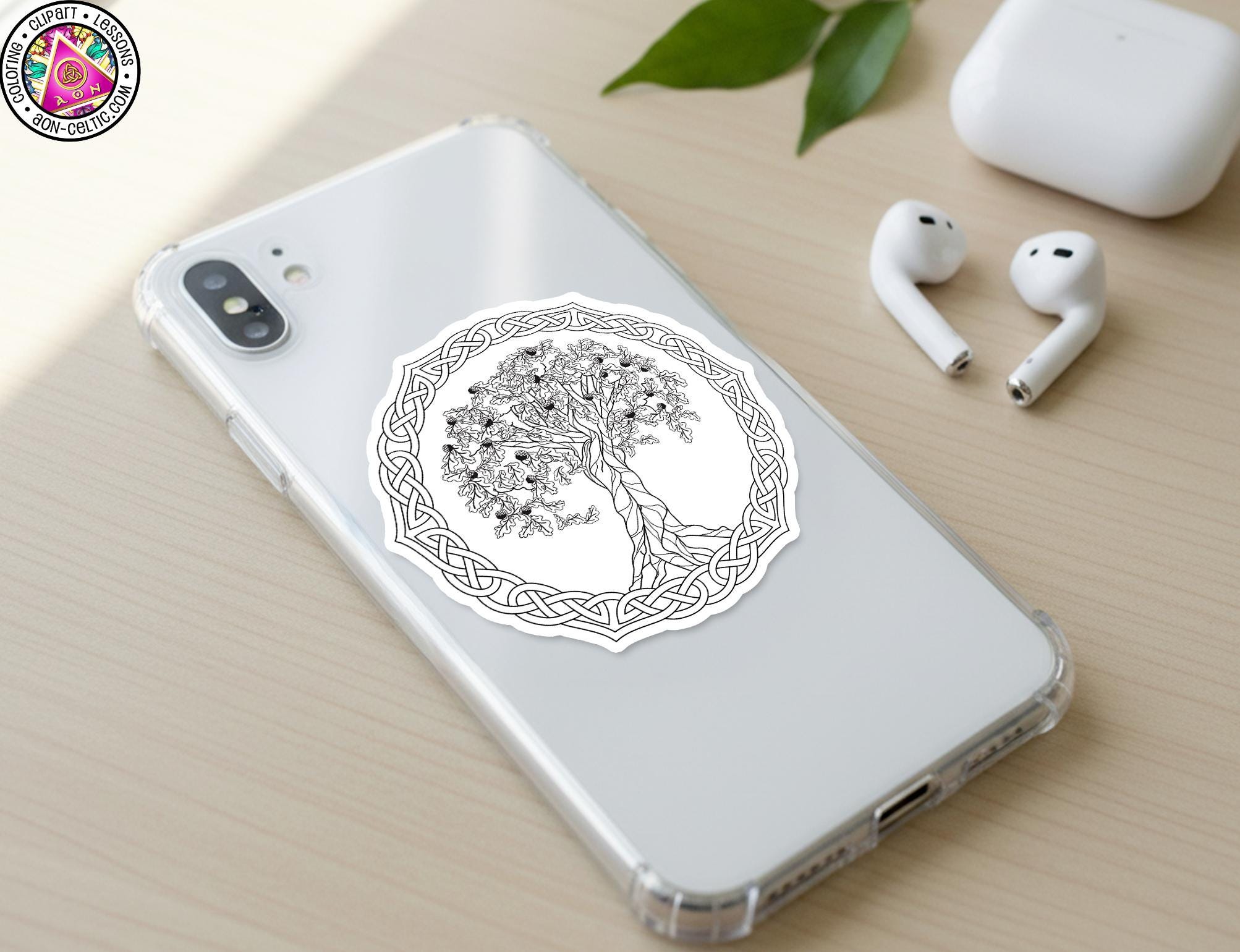 a smartphone with a sticker of a tree design on its back cover, along with a pair of earbuds and a white earbud case on a wooden surface.