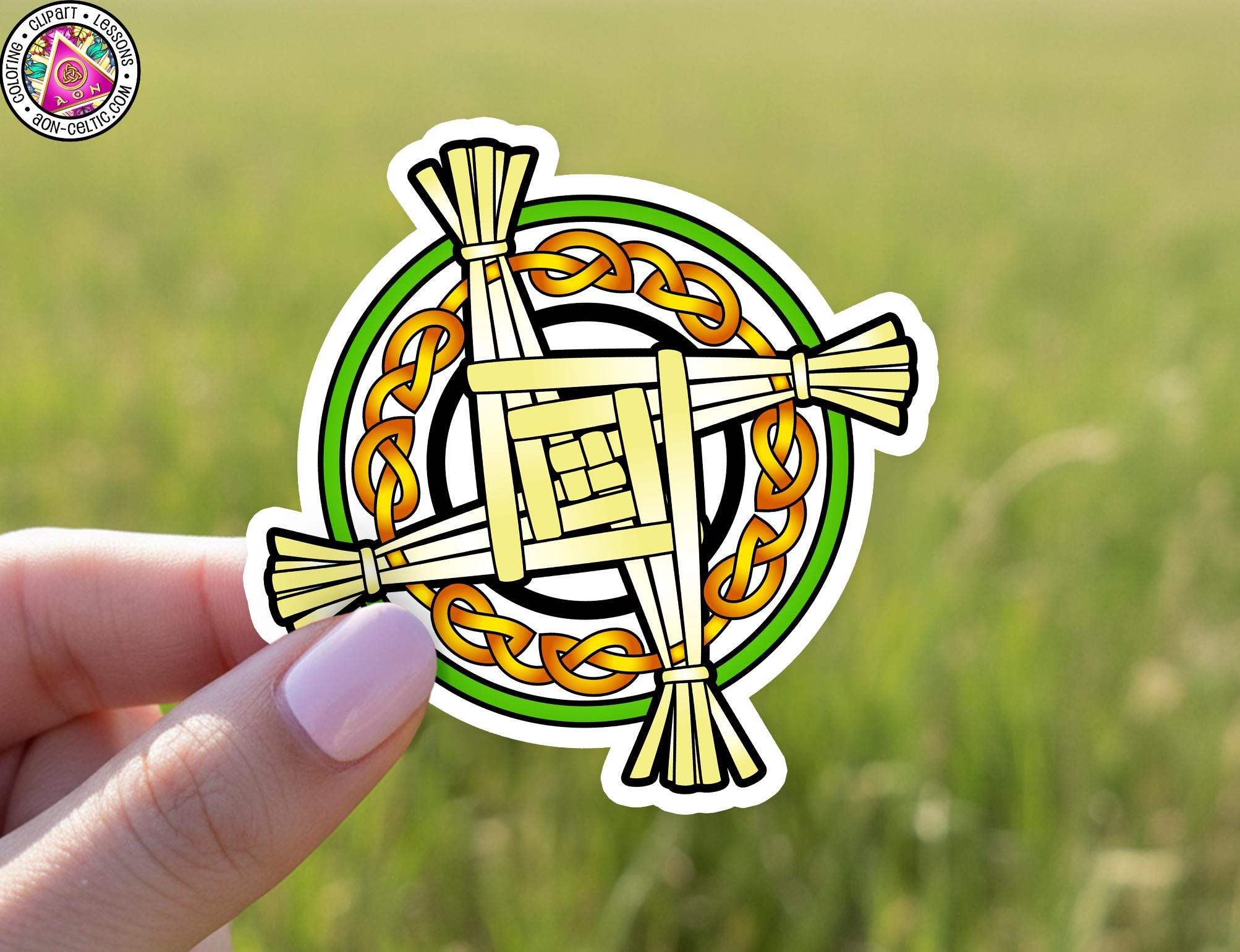 A hand holding a sticker with a colorful design featuring a cross and a circular pattern.