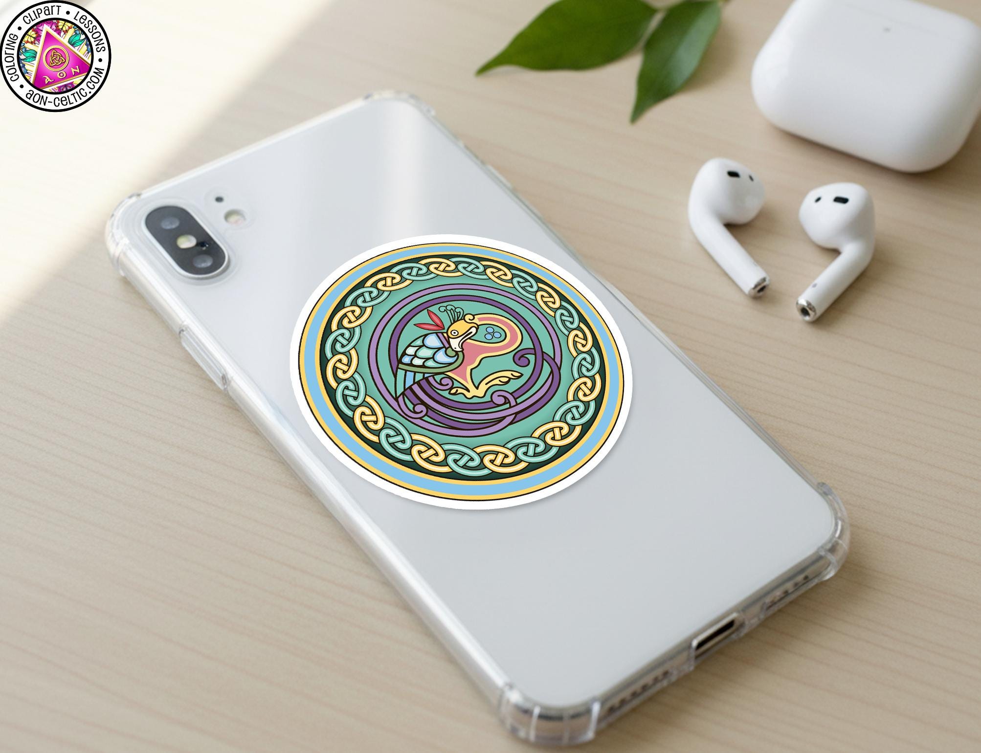 a smartphone with a colorful sticker on the back cover, along with a pair of earbuds and a white earbud case on a wooden surface.