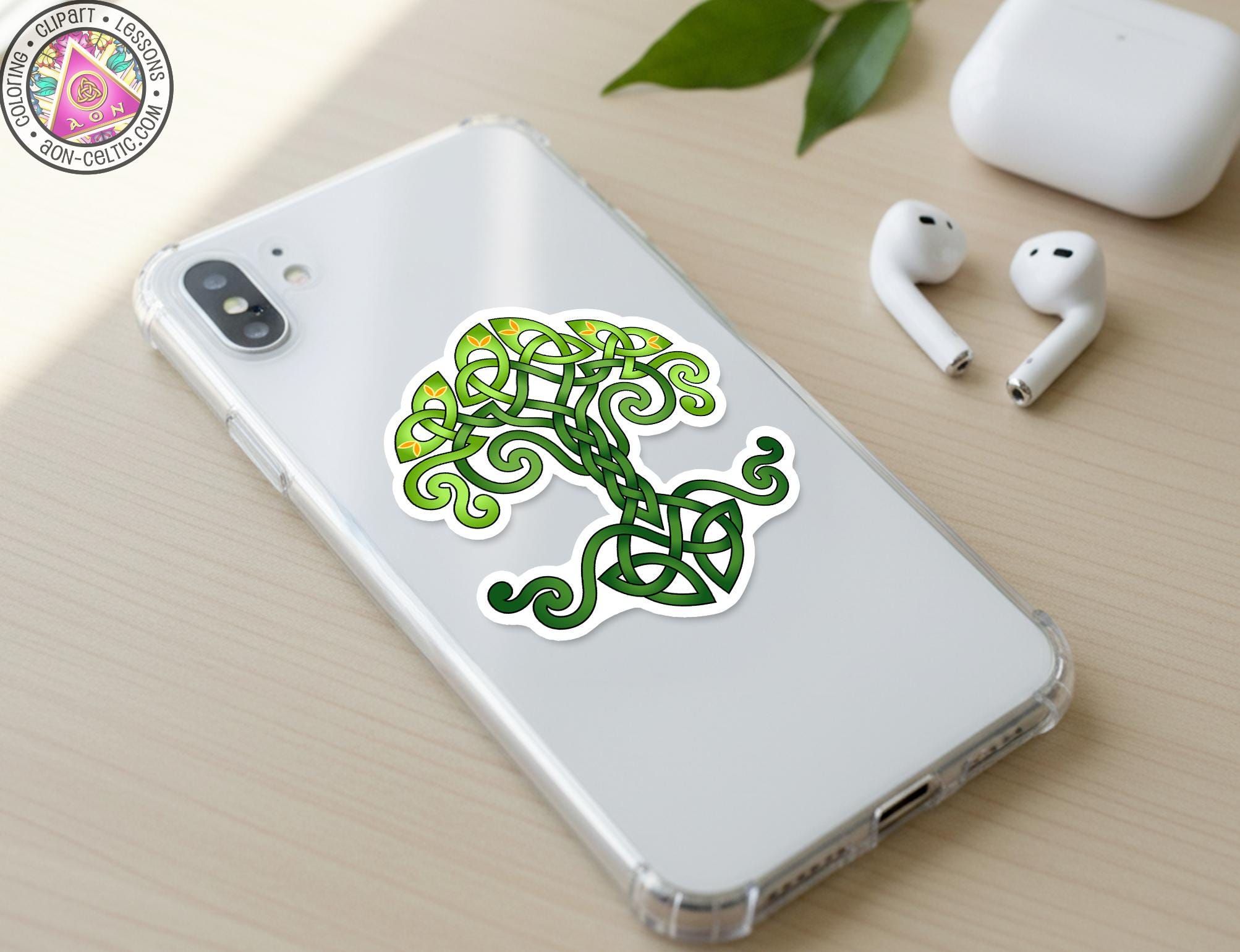 a smartphone with a sticker of a tree design on its back cover, along with a pair of earbuds and a white earbud case on a wooden surface.