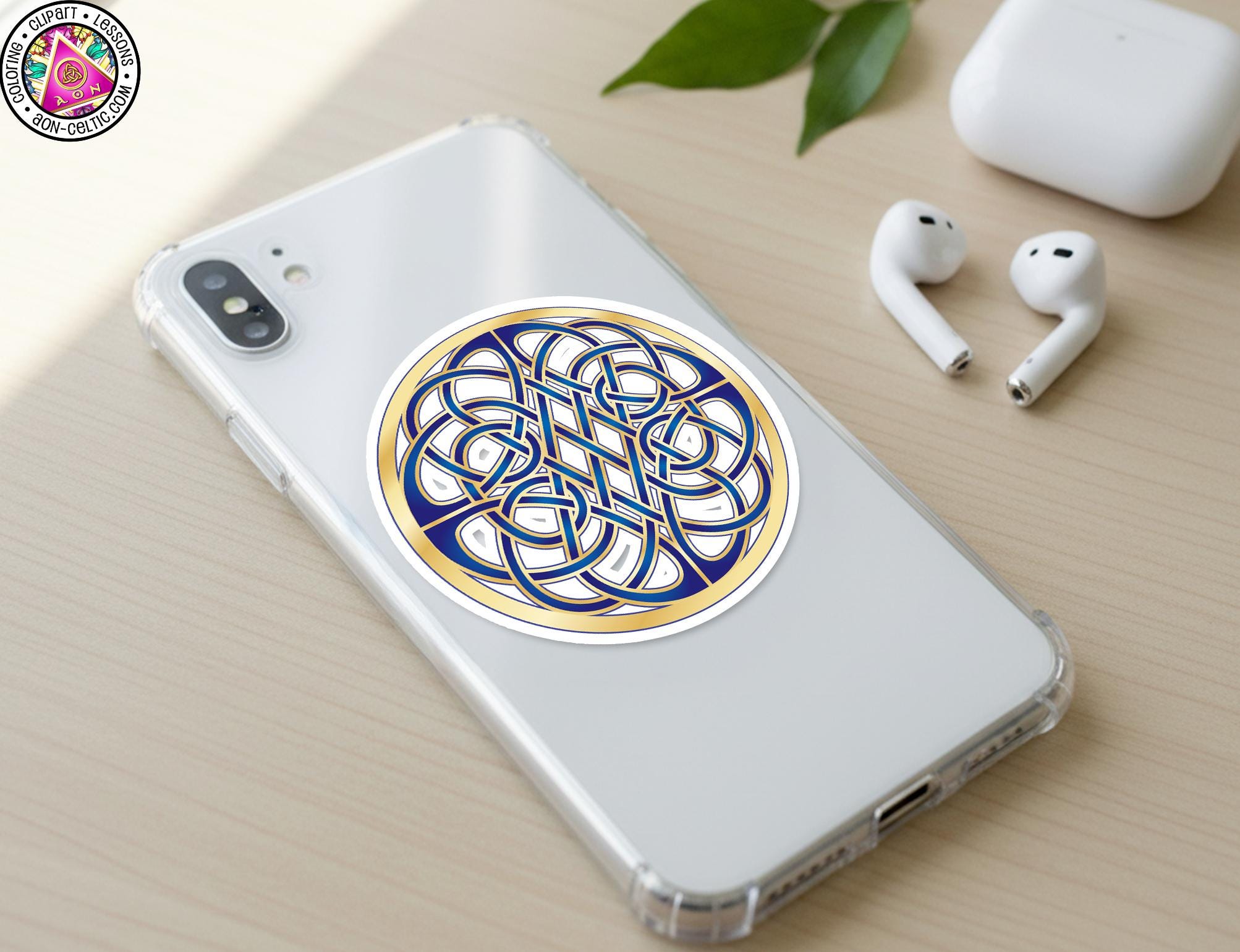 a smartphone with a decorative sticker on the back cover, along with a pair of earbuds and a white earbud case on a wooden surface.