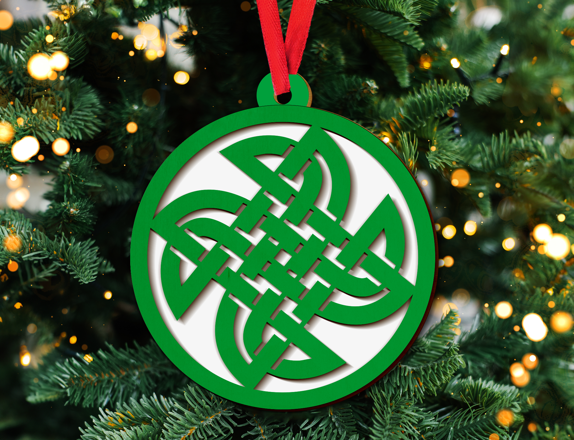 a green and white ornament hanging from a christmas tree