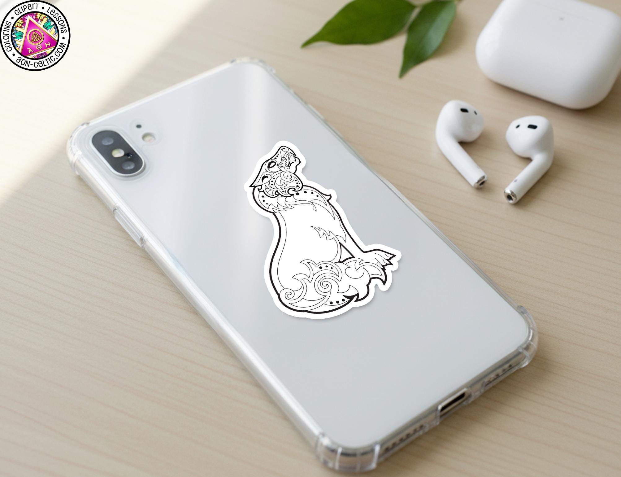 a smartphone with a sticker of a stylized fish or sea creature on its back cover, along with a pair of white earbuds and a white phone case.