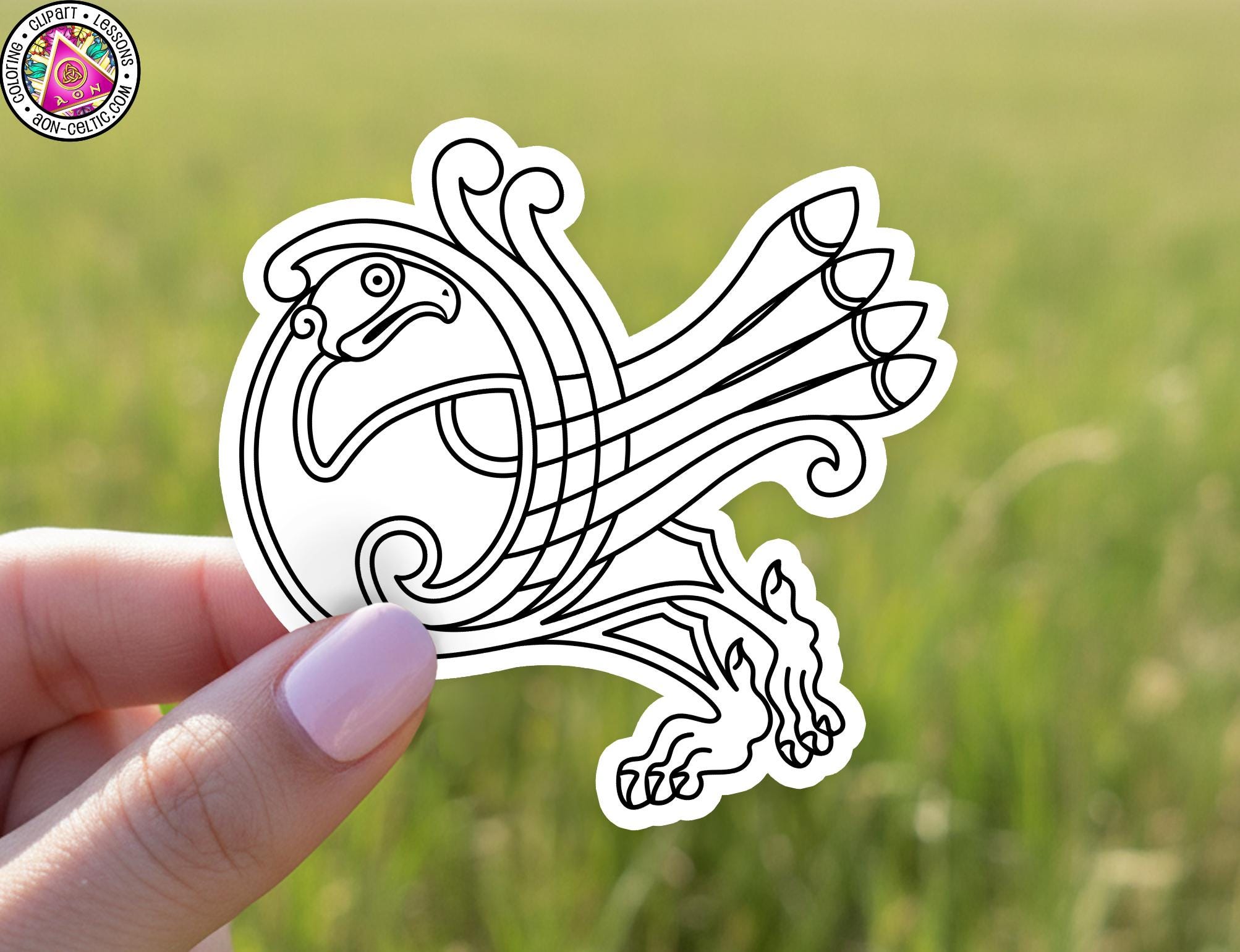 A hand holding a sticker with a stylized bird design on it.