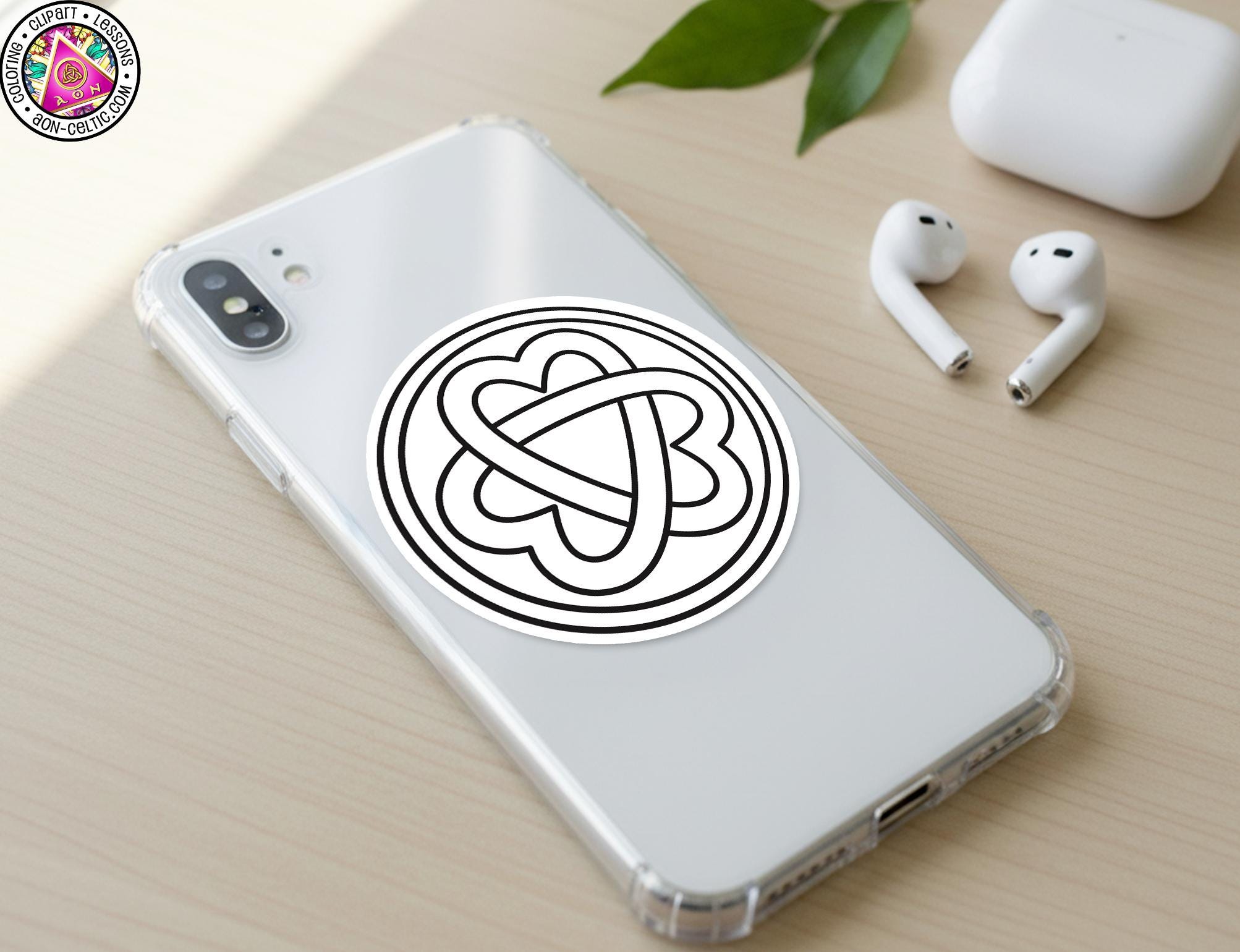 a smartphone with a sticker on the back, along with a pair of earbuds and a white earbud case on a wooden surface.