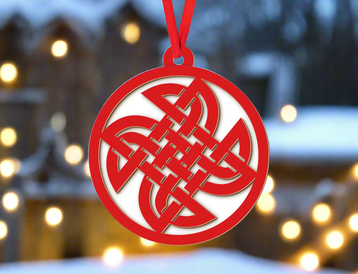 a red ornament hanging from a christmas tree