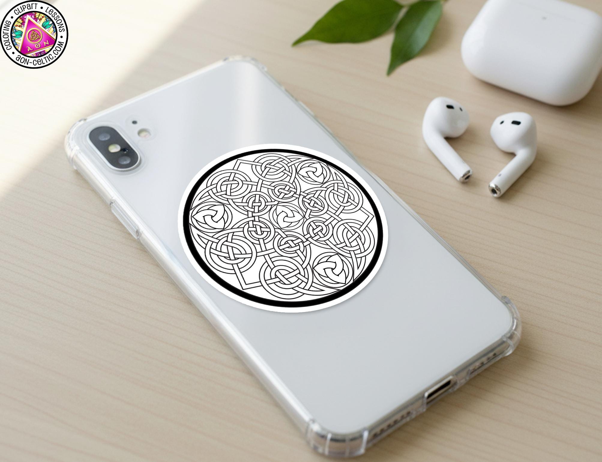 a smartphone with a sticker of a Celtic knot design on its back cover, along with a pair of white earbuds and a white phone case.
