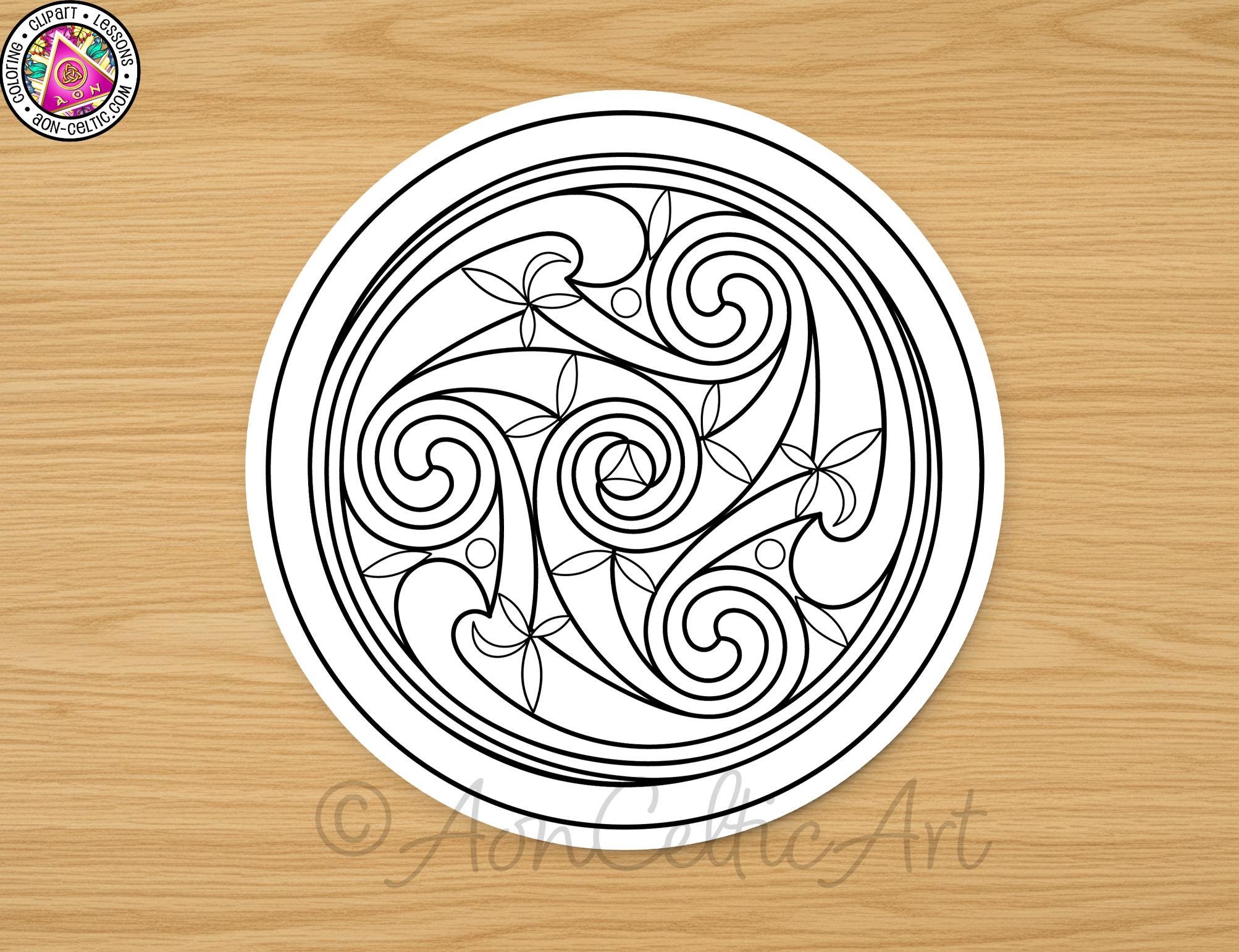 a circular design with swirls and flowers, placed on a wooden surface.