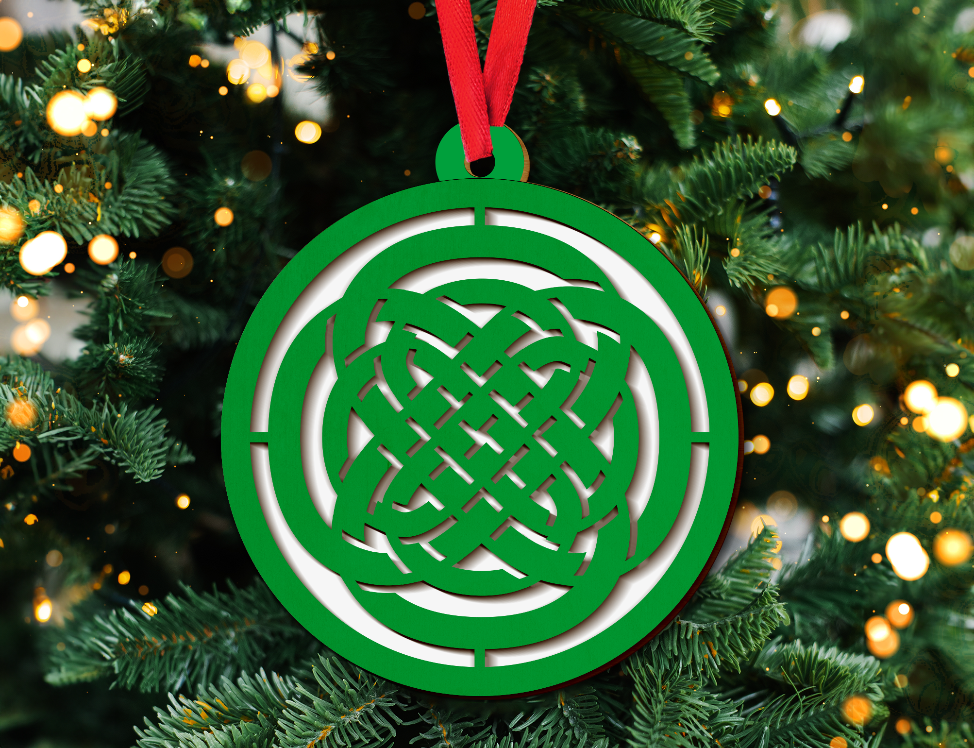 a green ornament hanging from a christmas tree