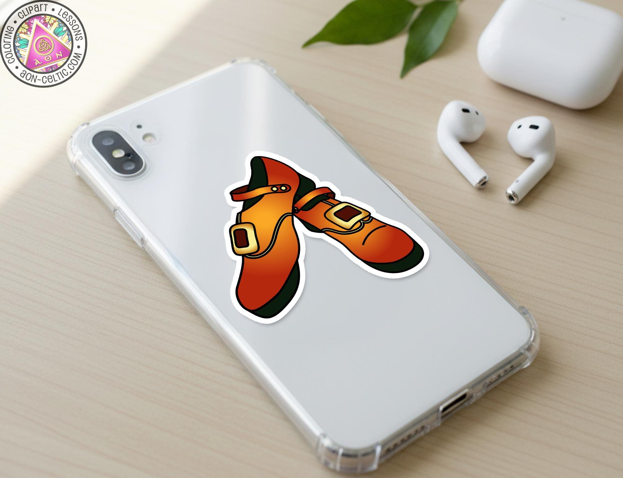 a smartphone with a sticker of a pair of orange shoes on its back cover, along with a pair of white earbuds and a white phone case.