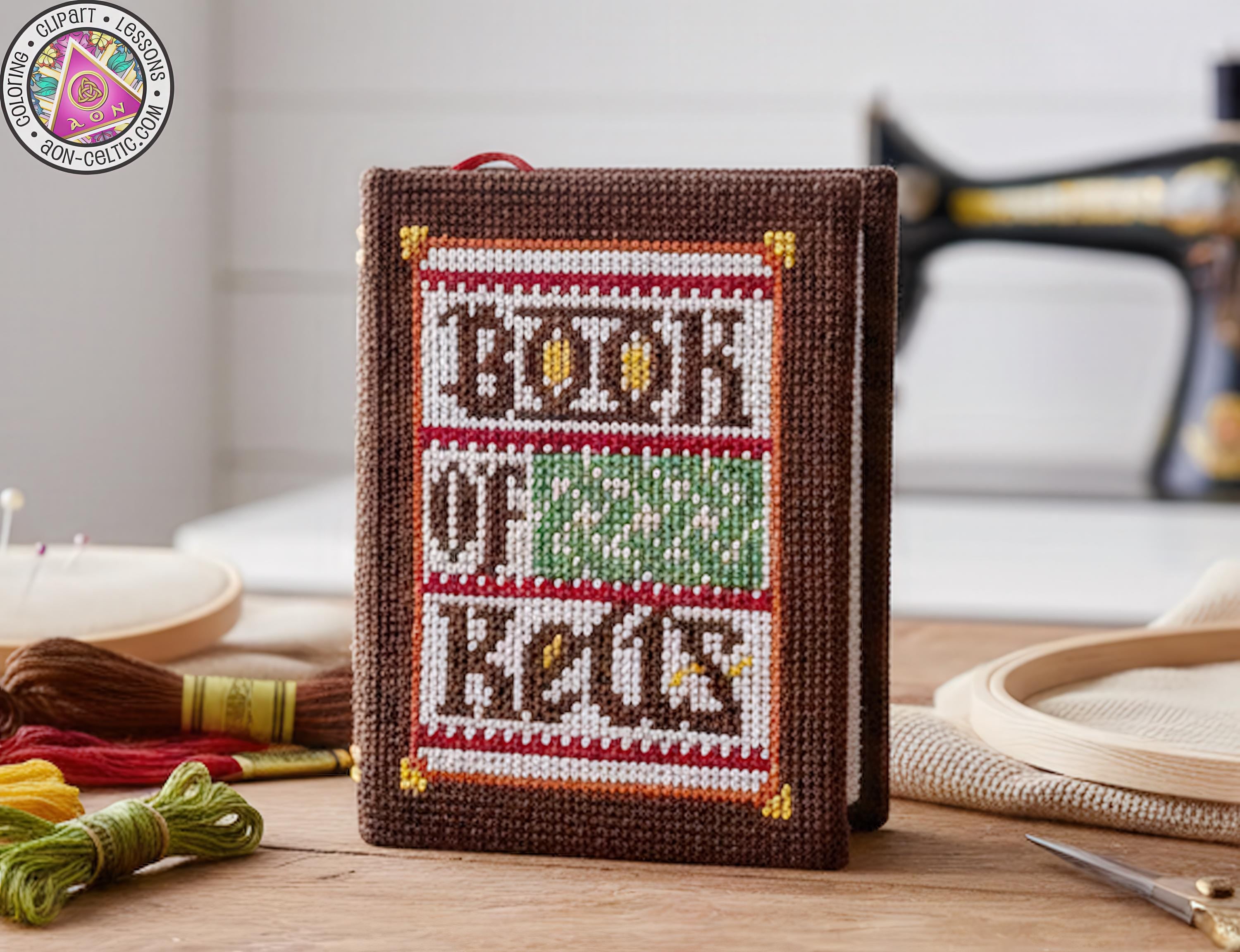 A hand-made book of keys, crafted from brown fabric, sits on a wooden surface surrounded by sewing supplies.