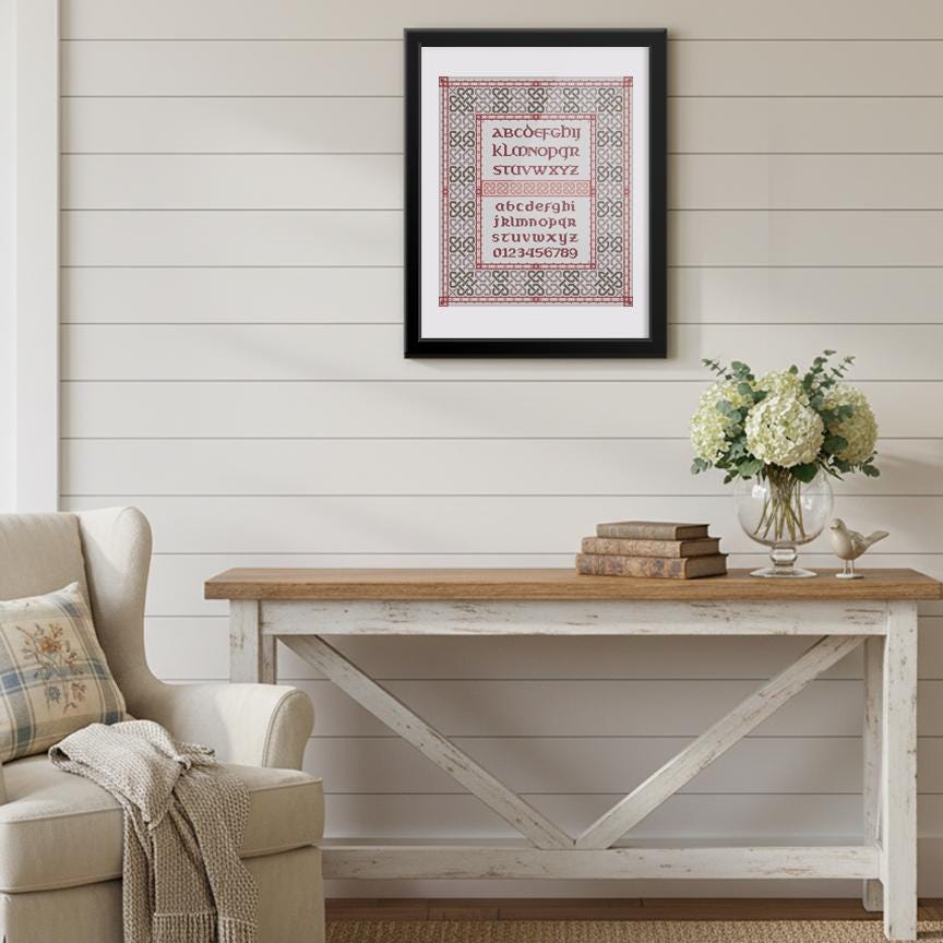 a cozy living room with a white wooden table, a beige armchair, and a framed poster on the wall. The poster displays the alphabet in a decorative and artistic manner, adding a unique touch to the room&#39;s decor.