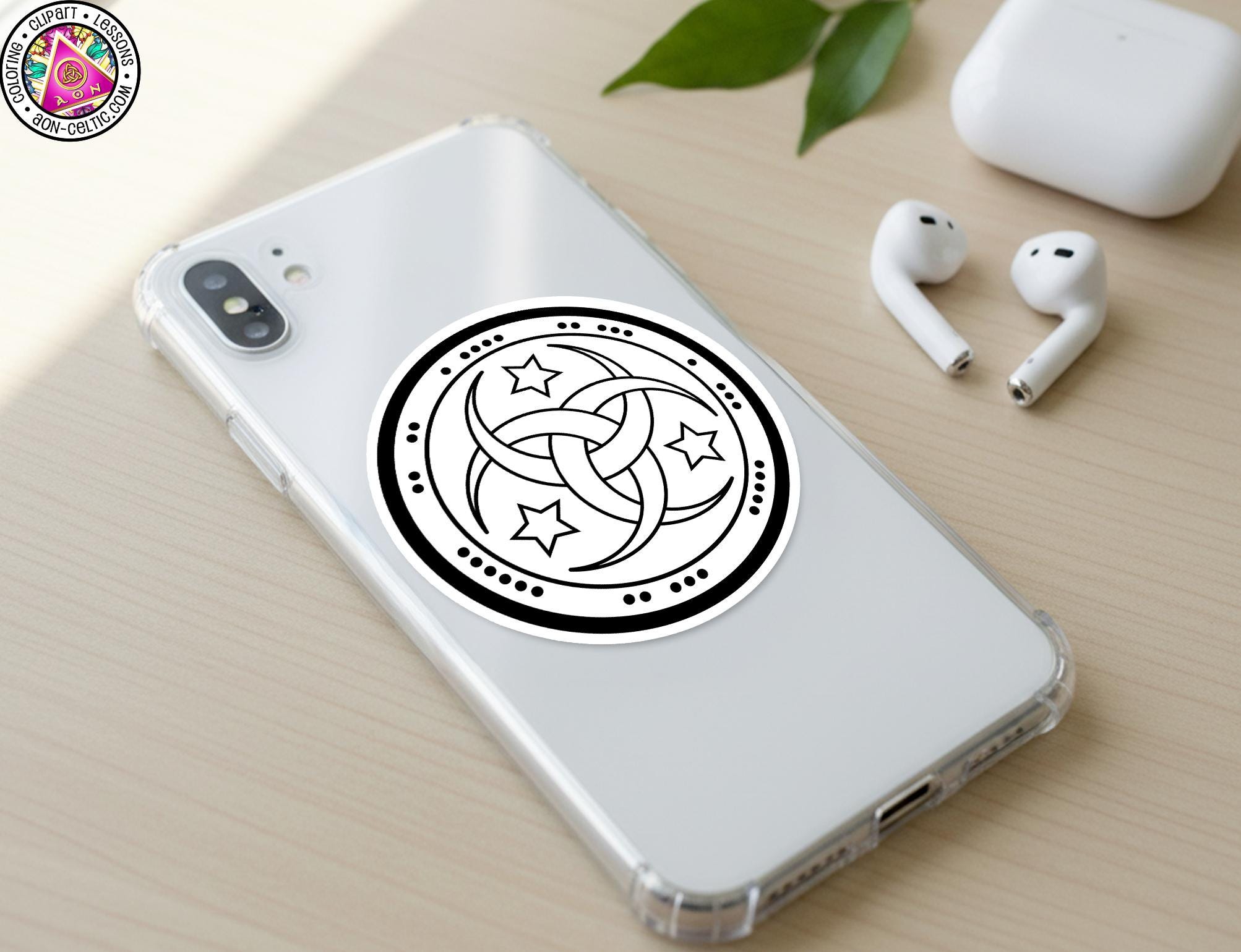 a smartphone with a sticker on the back cover, along with a pair of earbuds and a white earbud case on a wooden surface.