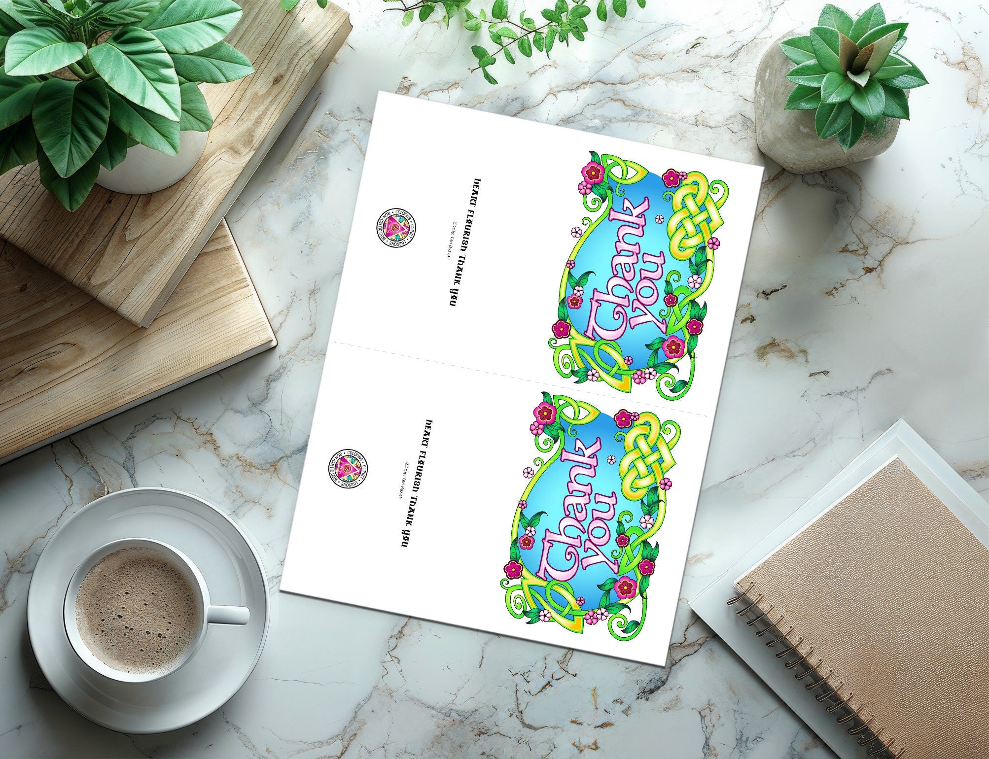 a cup of coffee sitting next to a paper with a design on it