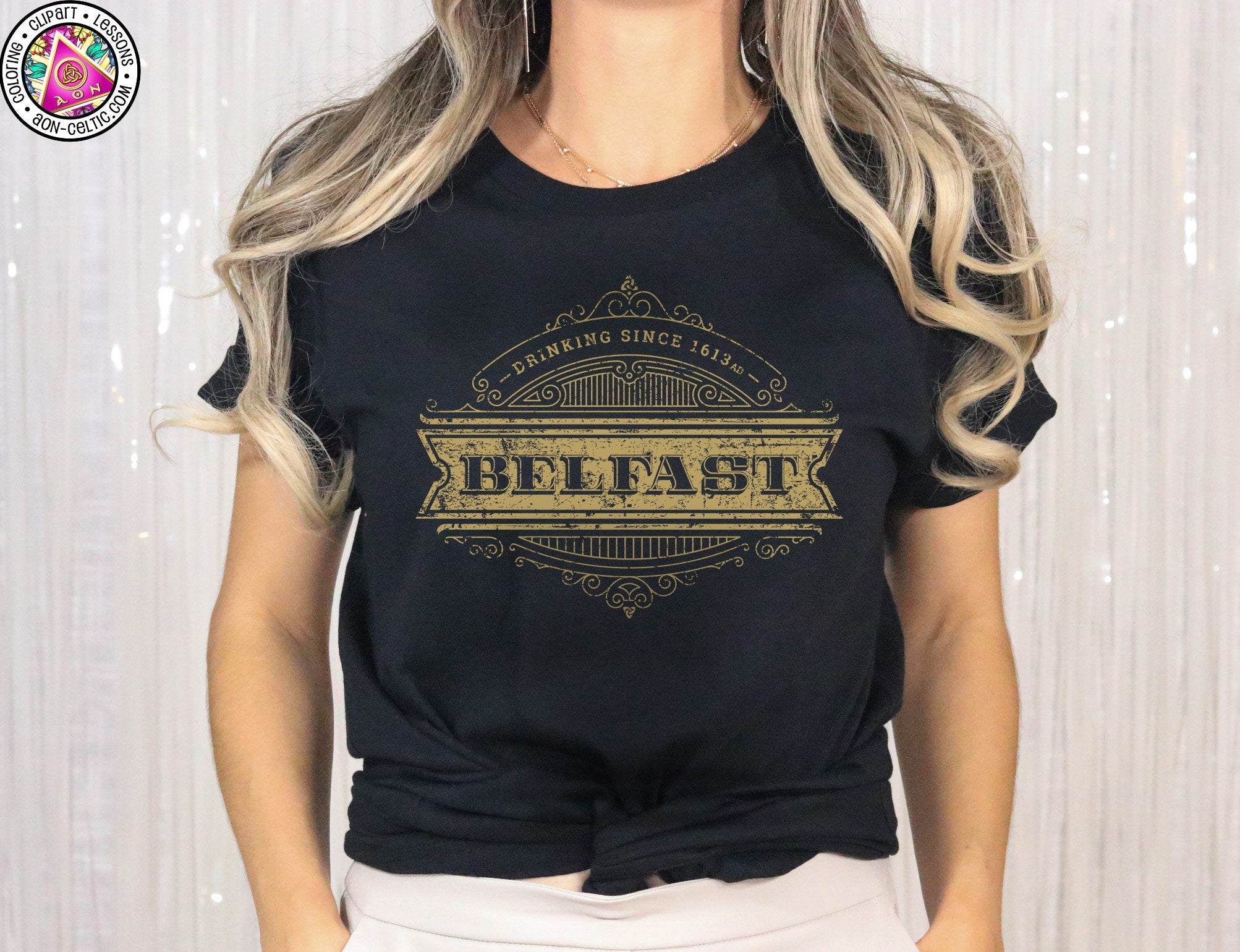 a woman wearing a black t - shirt with gold lettering